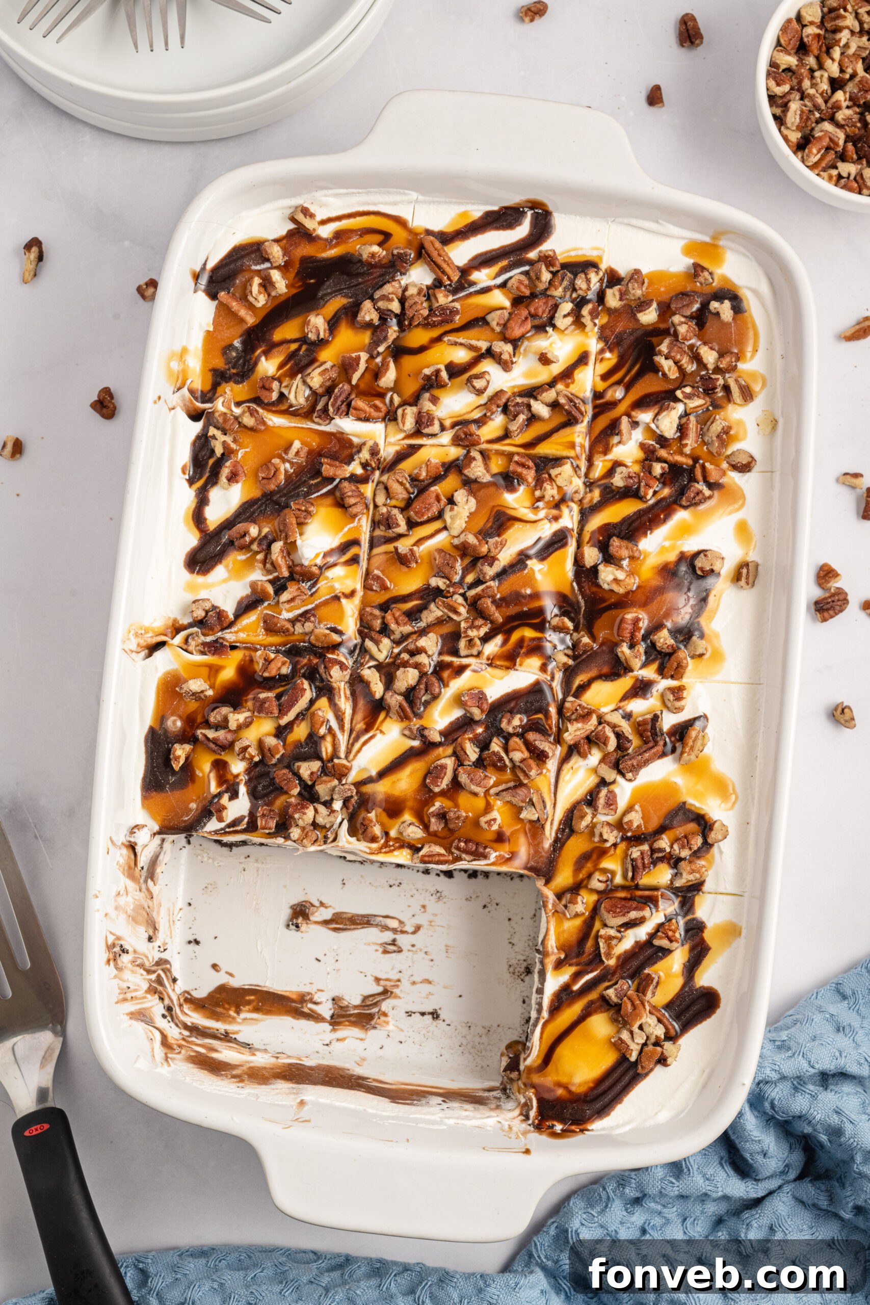 Overhead view of Turtle Lush in a white baking dish with two perfectly sliced portions removed, highlighting the layers.