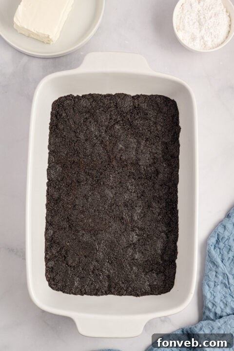 Step-by-step image of combining Oreo crumbs and butter for the crust.
