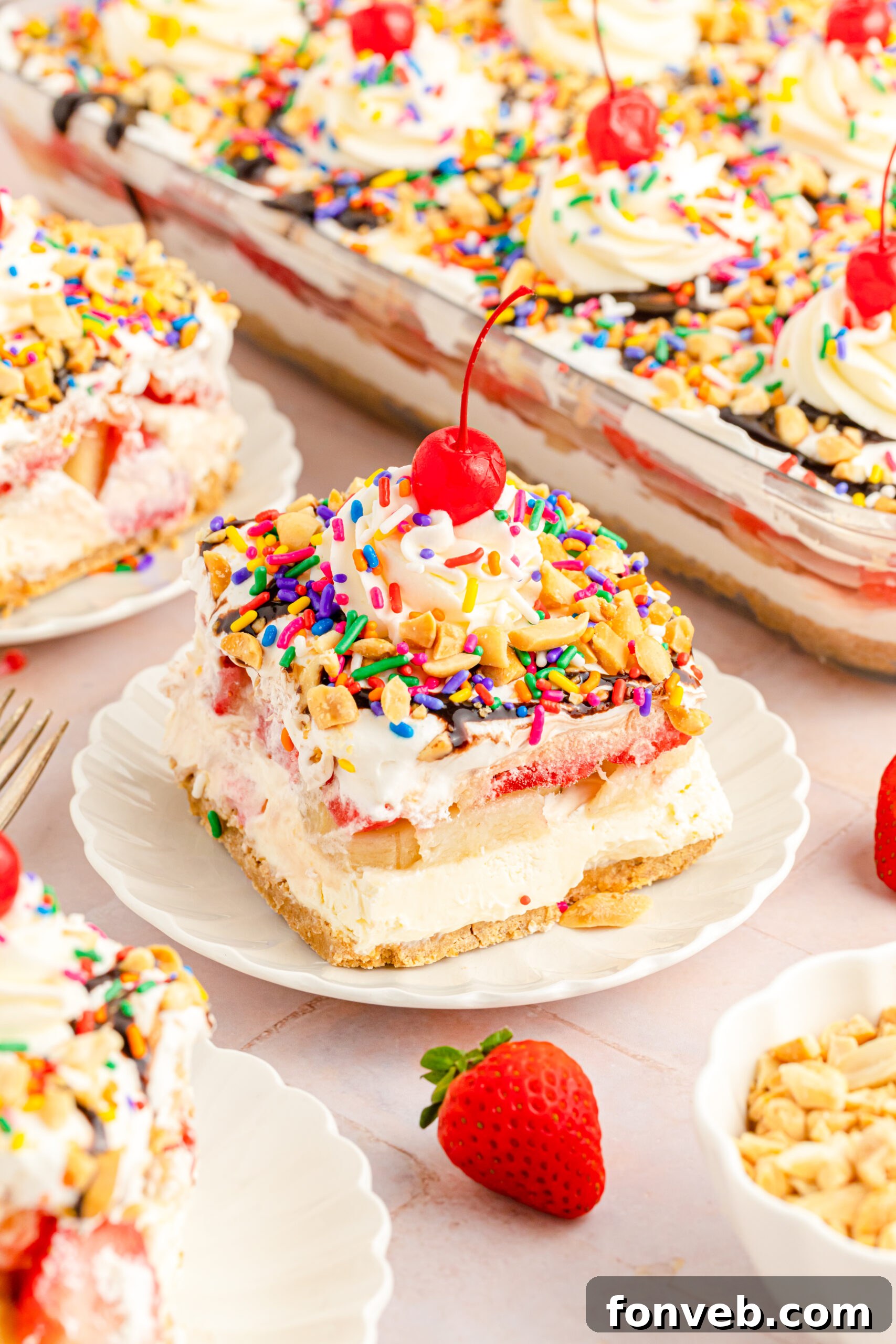 A beautifully presented slice of No-Bake Banana Split Cake on a white plate, ready to be savored.