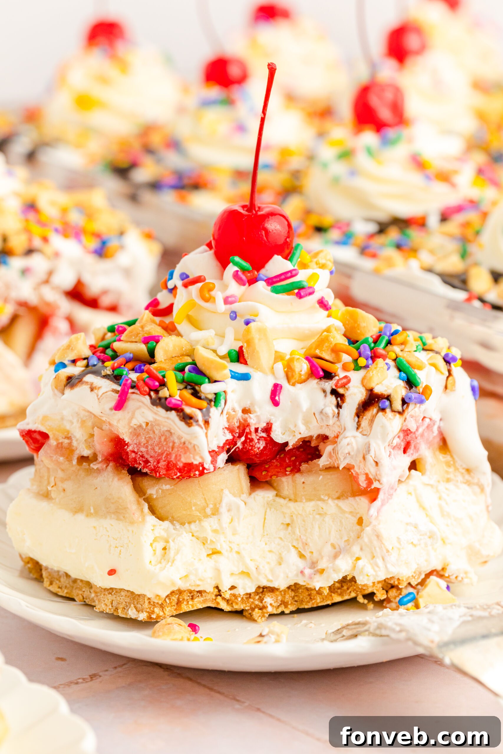 A detailed close-up of a slice of No-Bake Banana Split Cake, with a fork showing a removed bite, emphasizing the inviting texture and delicious layers.