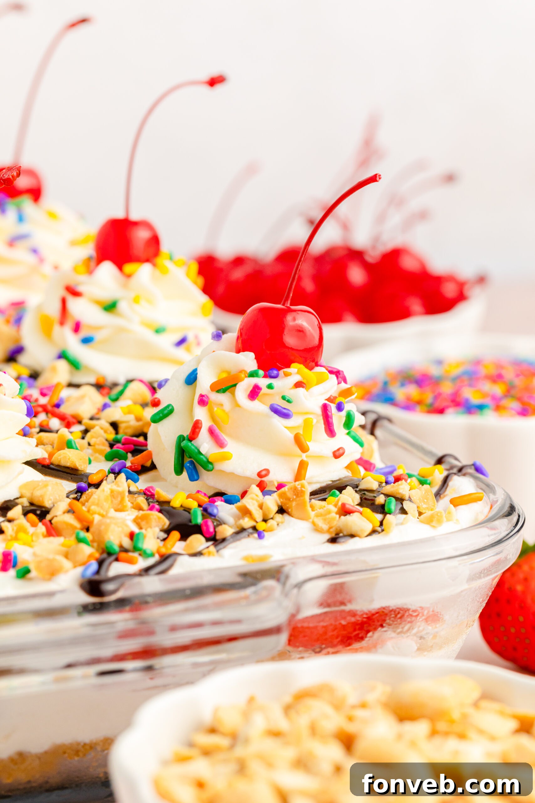 A side view of the No-Bake Banana Split Cake in a clear baking dish, emphasizing the layers and the generous whipped topping.