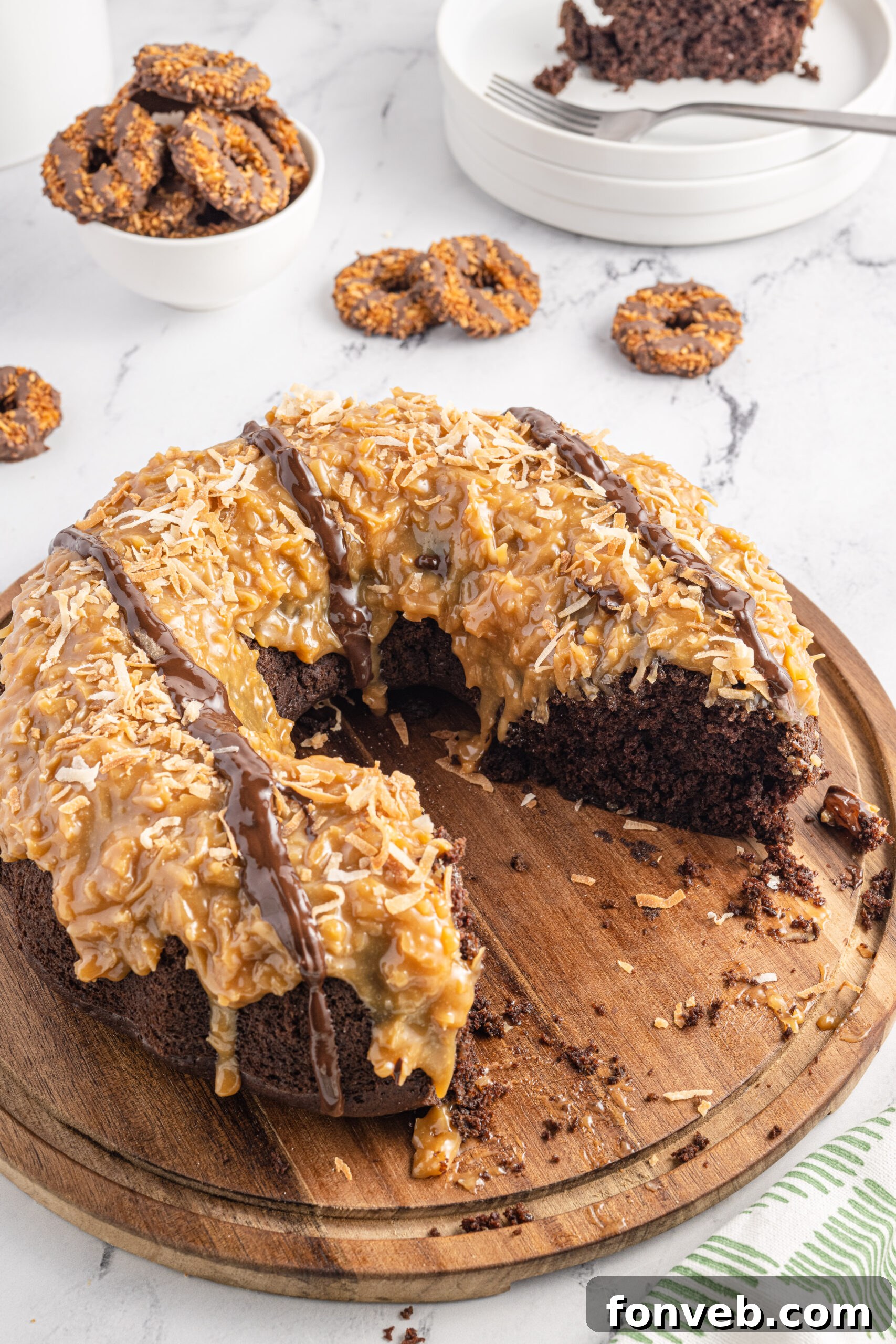 Overhead view of Samoa Cake on a wooden cutting board with slices removed.
