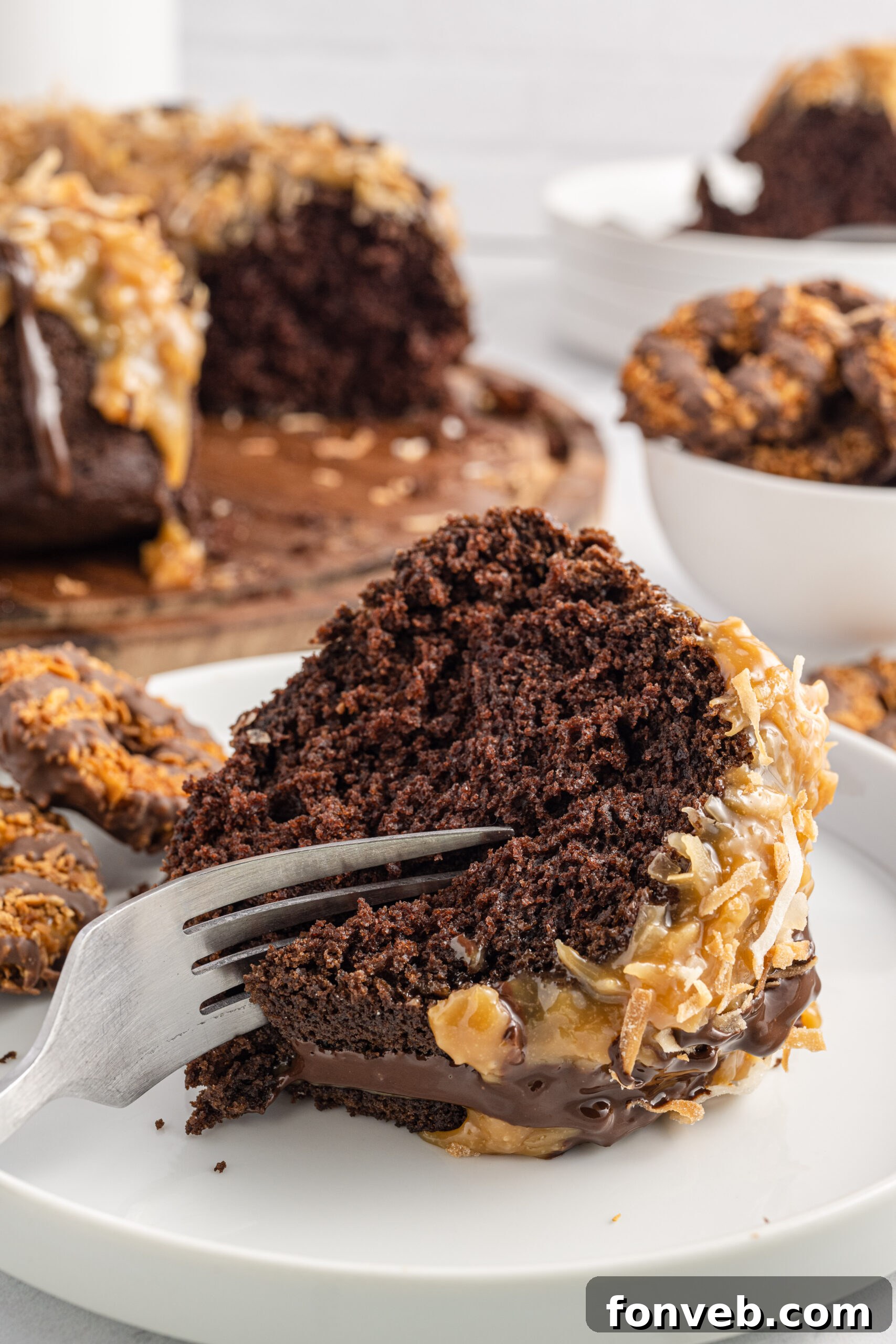 Front view of a silver fork removing a bite from a slice of Samoa Cake.