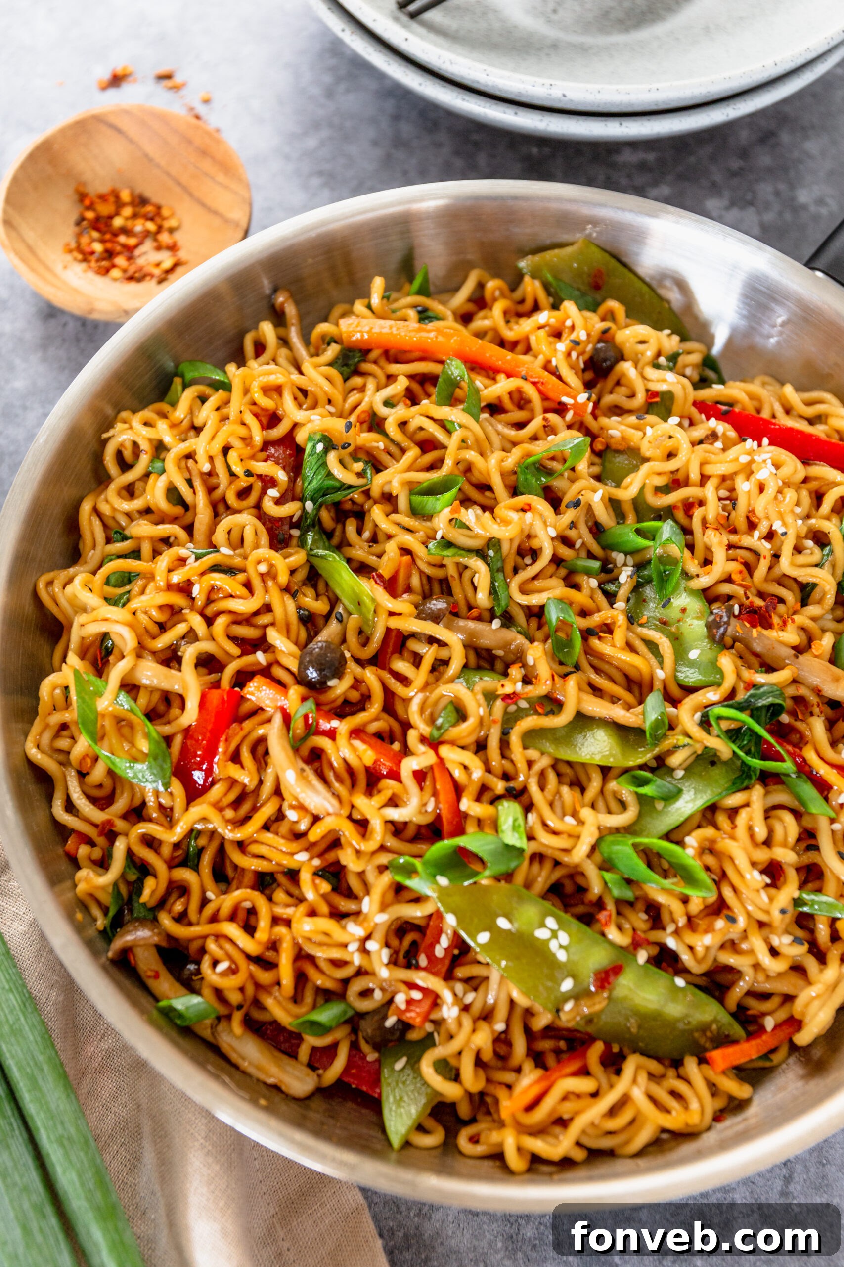 Ramen Stir Fry in a silver frying pan topped with sesame seeds. 