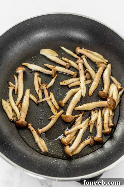 Sesame oil being added to a bowl of sauce.