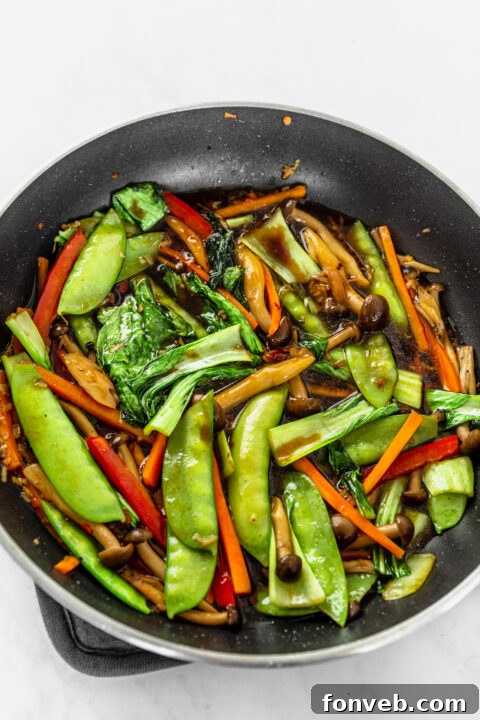 Dark soy sauce being added to a bowl of sauce.