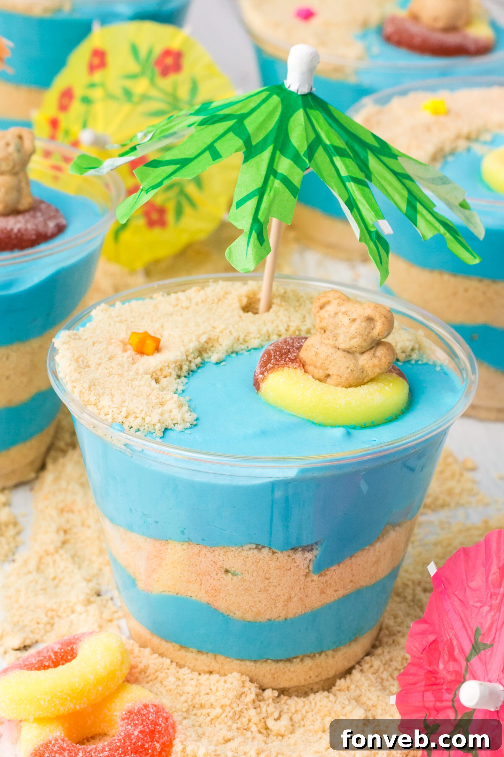 Overhead shot of beautifully arranged Beach Cheesecake Pudding Cups, showcasing the blue pudding and cookie sand layers.