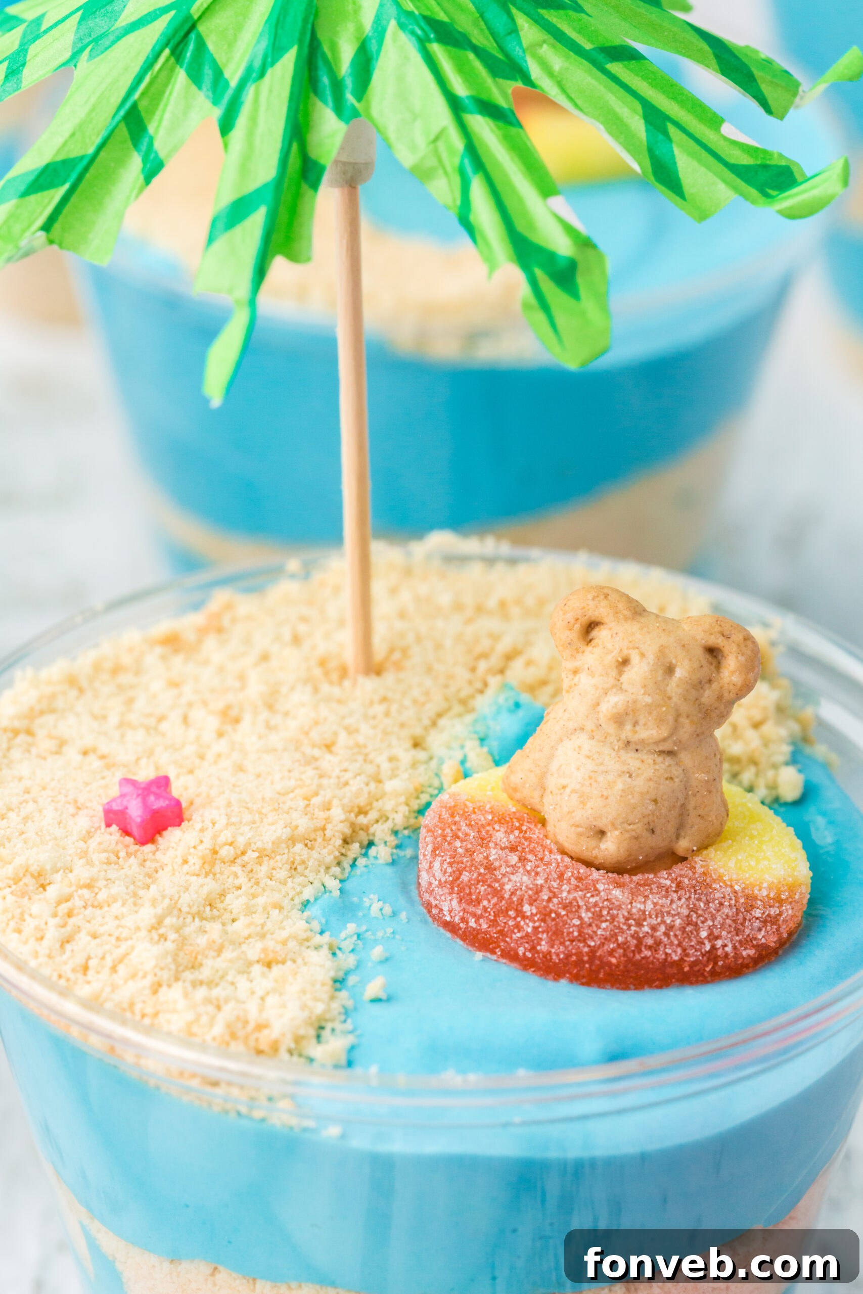 Close up view of the teddy graham bear and peach gummy ring 'float' in the blue pudding ocean.