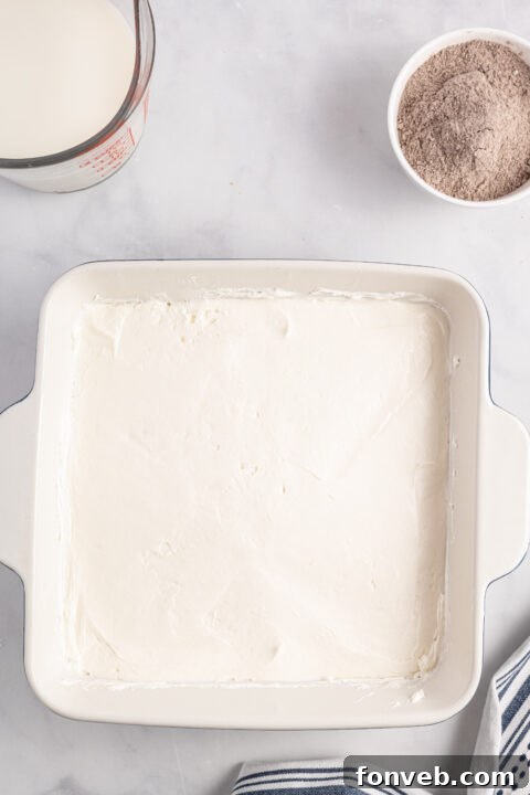 Whipped topping being folded into the cream cheese mixture.