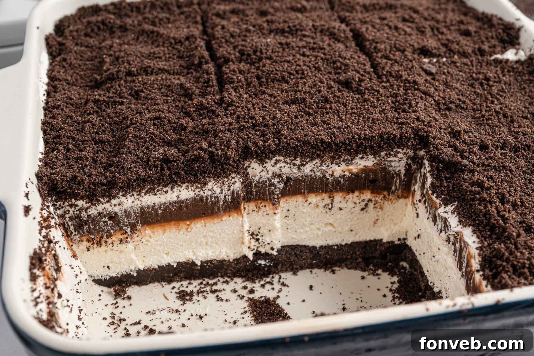 side view of Oreo Delight in a baking dish cut into slices with two removed.