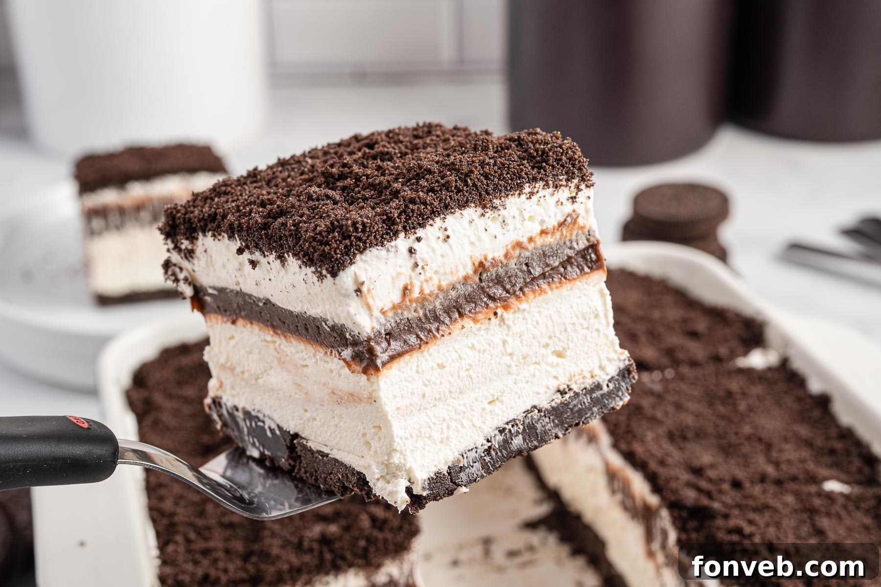 Front view of a slice of Oreo Delight on a silver cake server.