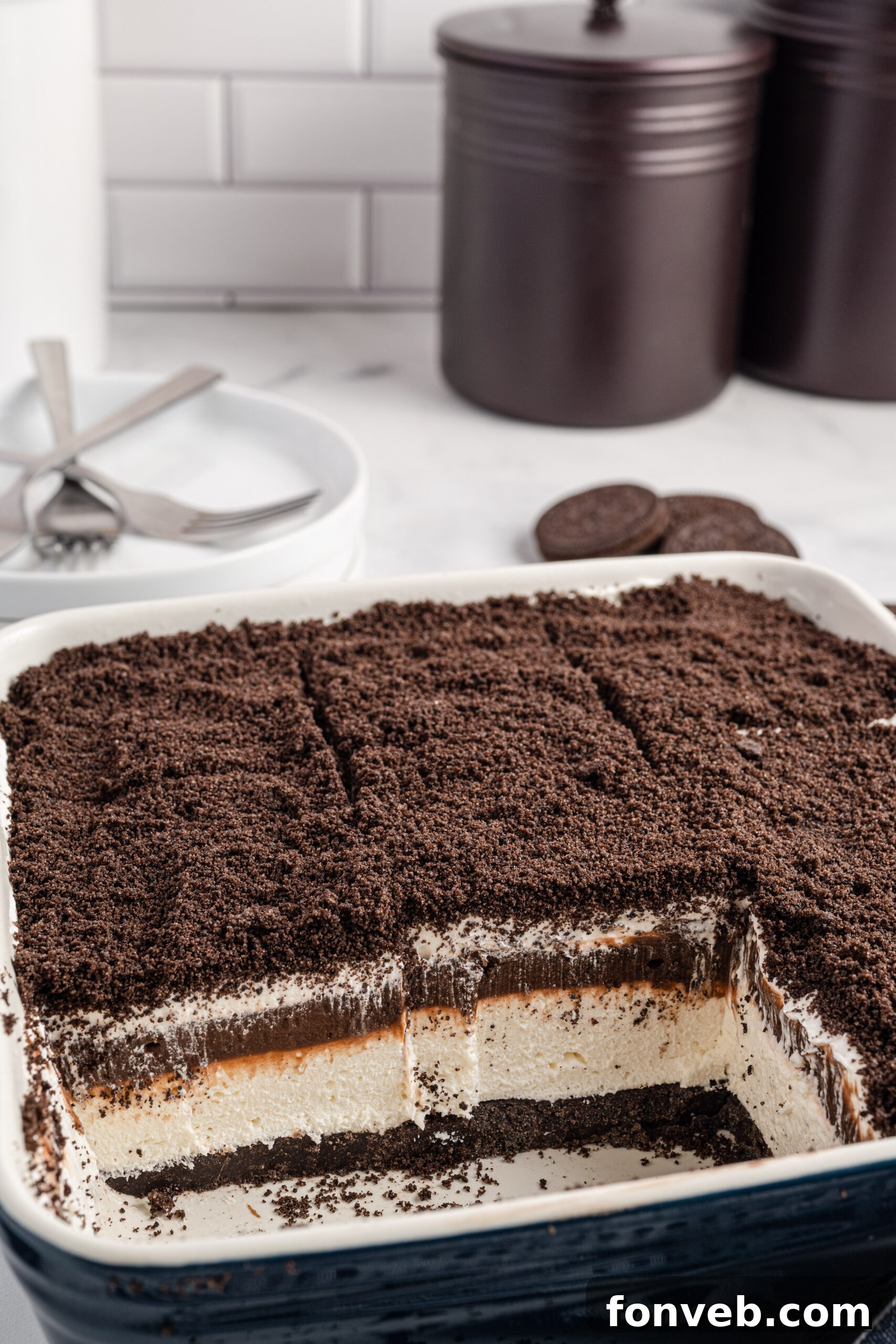 Front view of Oreo Delight in a baking dish cut into slices with two removed.