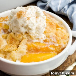 Simple Peach Dump Cake 19 A top-down view of a golden-brown Peach Dump Cake in a white baking dish, with a slice removed, revealing the juicy peach filling.