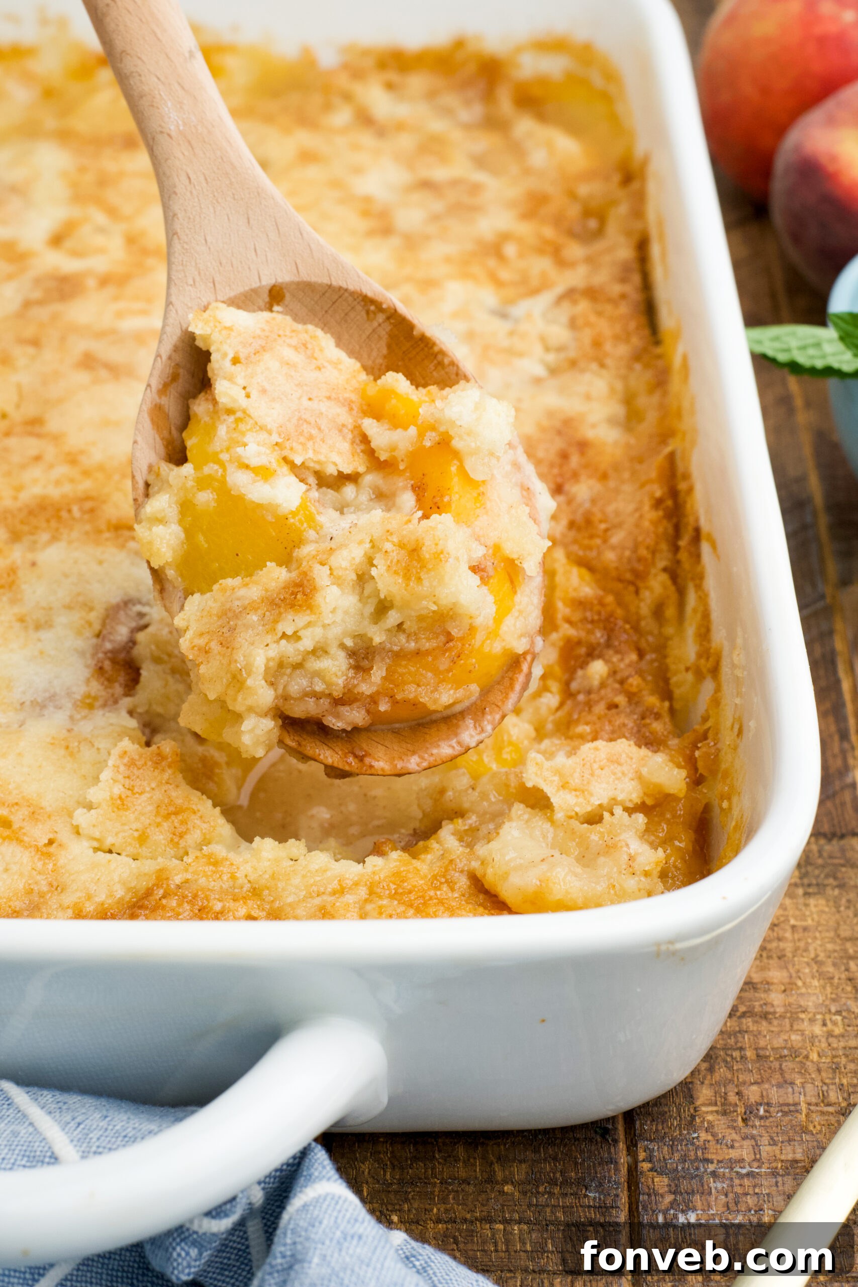 Simple Peach Dump Cake 3 Close up view of a wooden spoon with a spoonful of Peach Dump Cake.