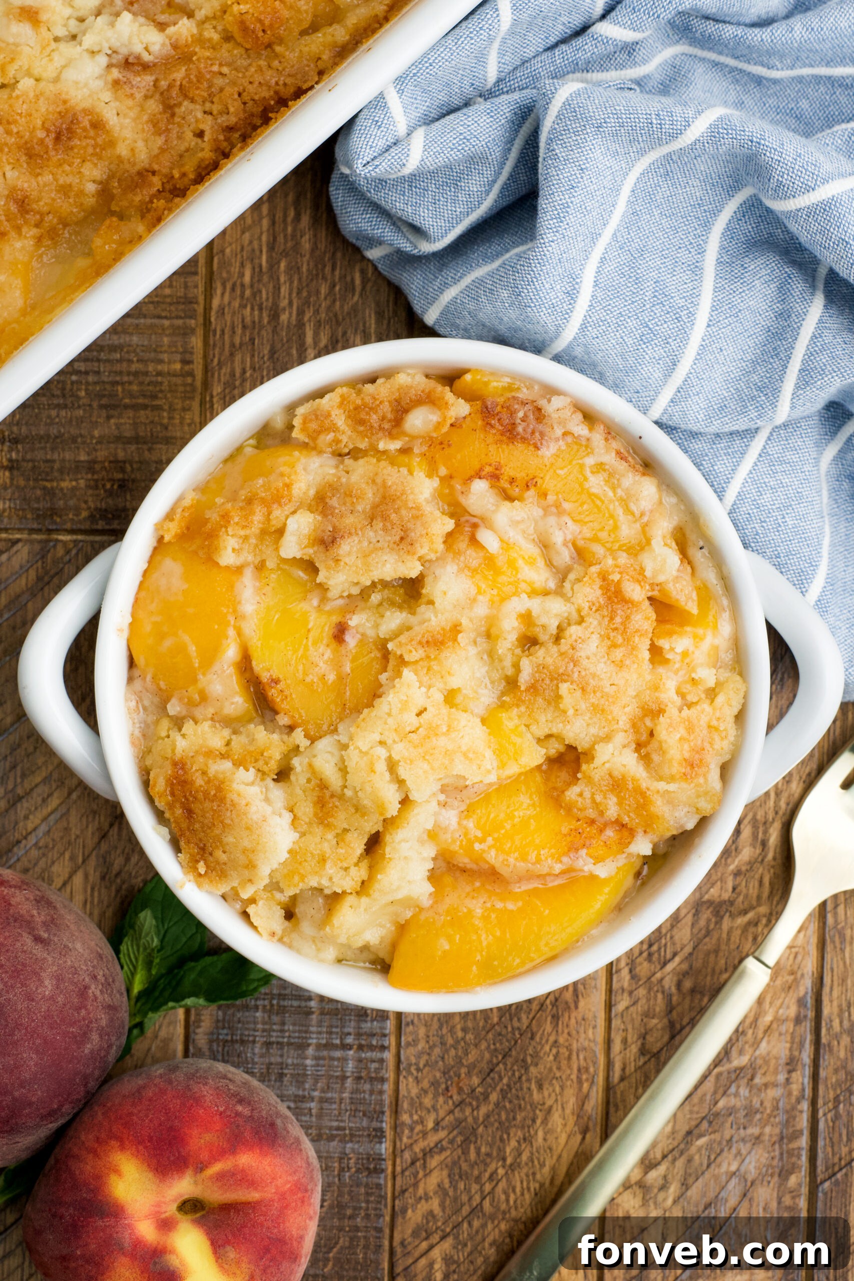 Simple Peach Dump Cake 5 Overhead view of a serving of Peach Dump Cake in a white bowl.