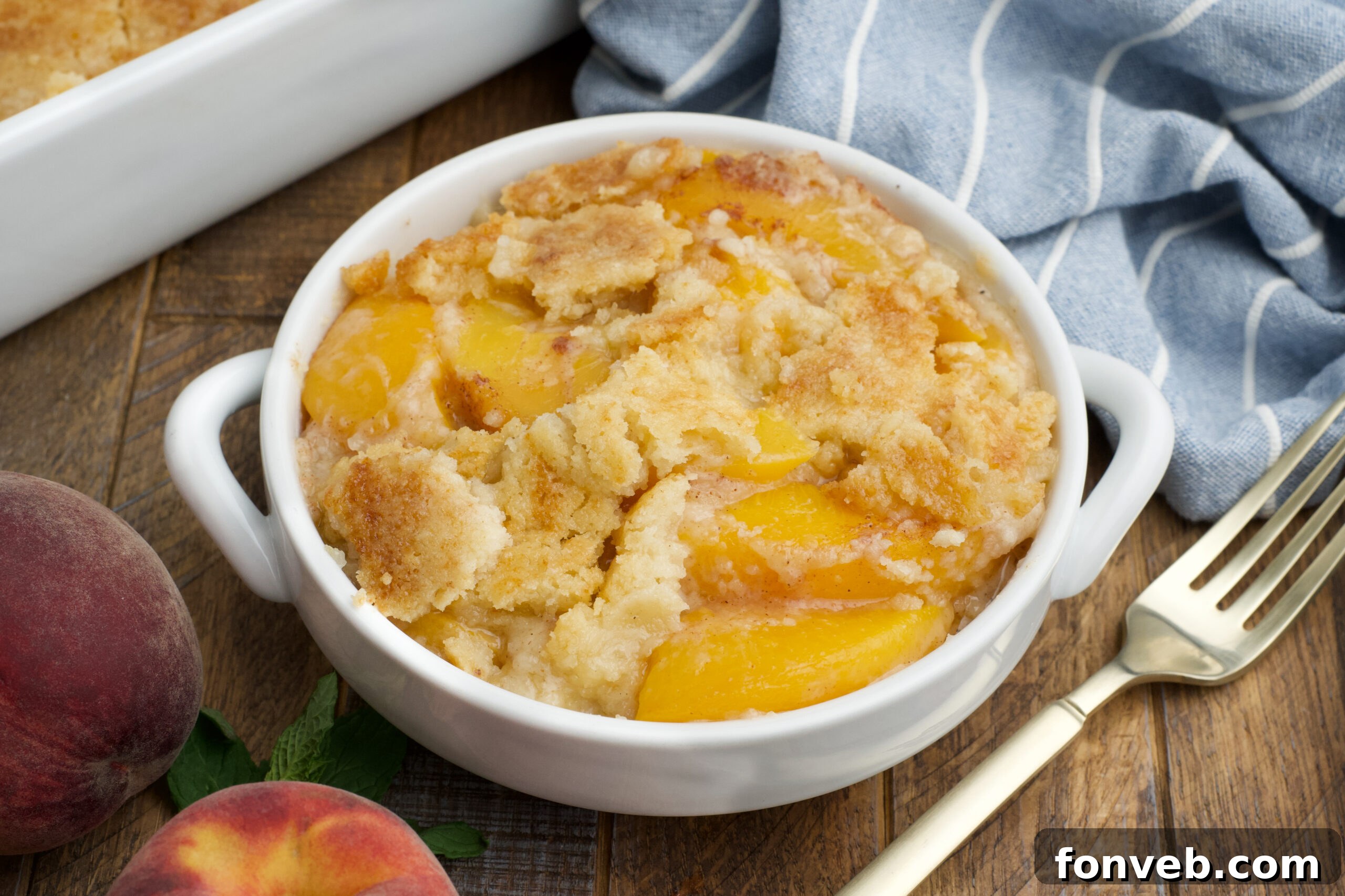 Simple Peach Dump Cake 6 Overhead view of a serving of Peach Dump Cake in a white bowl.