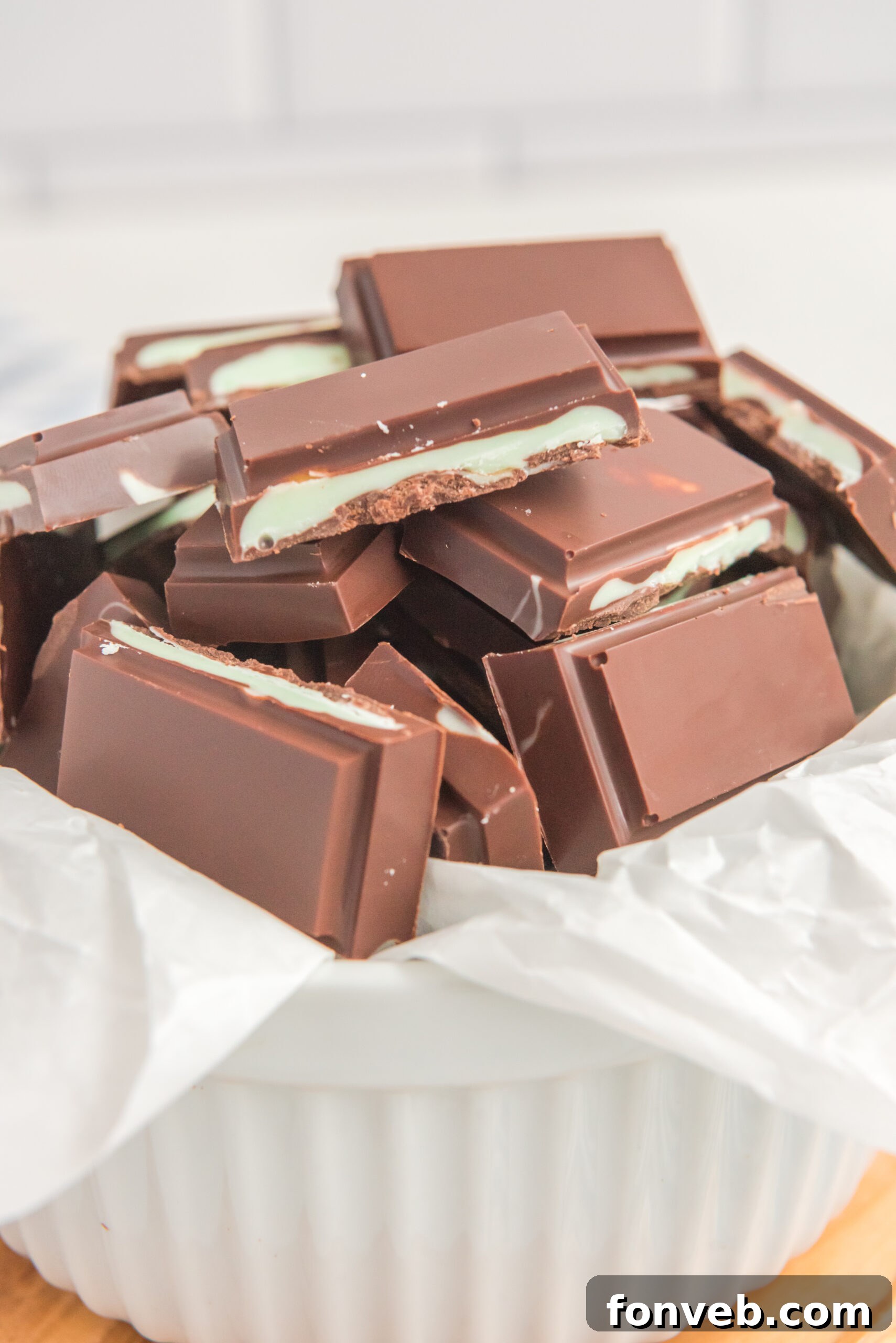 Front view of Homemade Andes Mints in a white bowl lined with parchment paper.