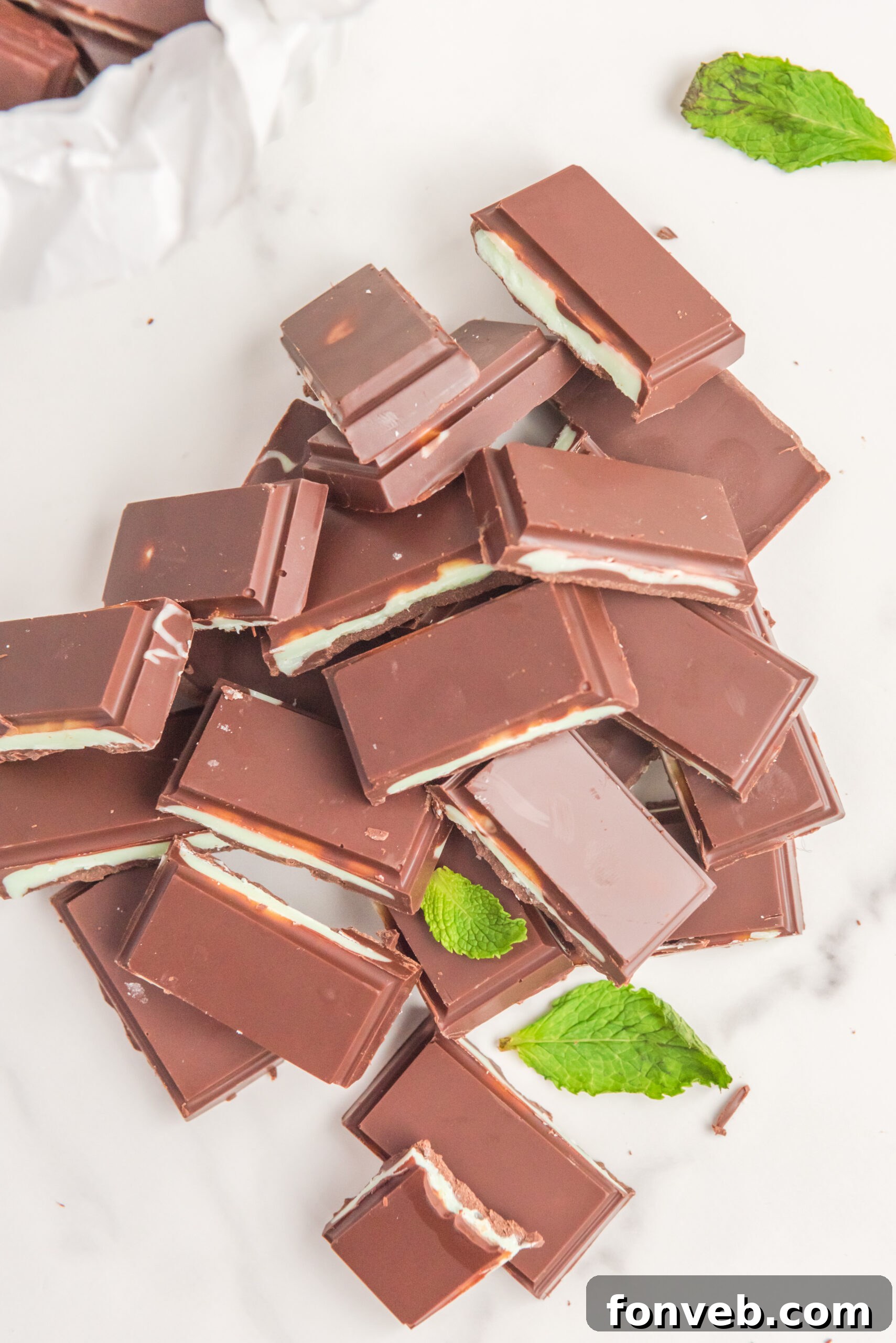 Overhead view of a pile of Homemade Andes Mints with a bite removed from one mint.
