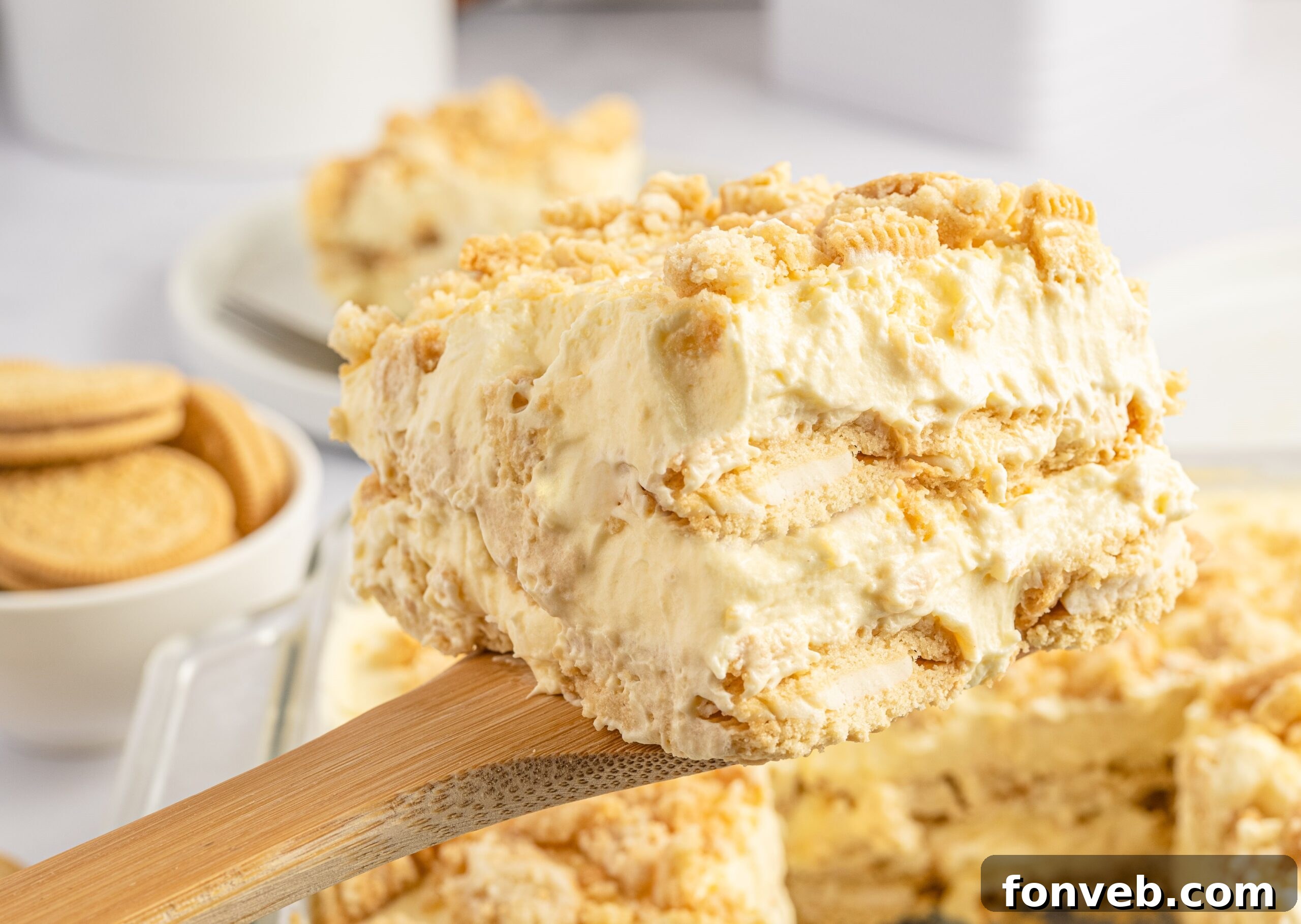 Golden Oreo No-Bake Delight 17 Close up view of a slice of Golden Oreo Icebox Cake being lifted up on a wooden spoon.