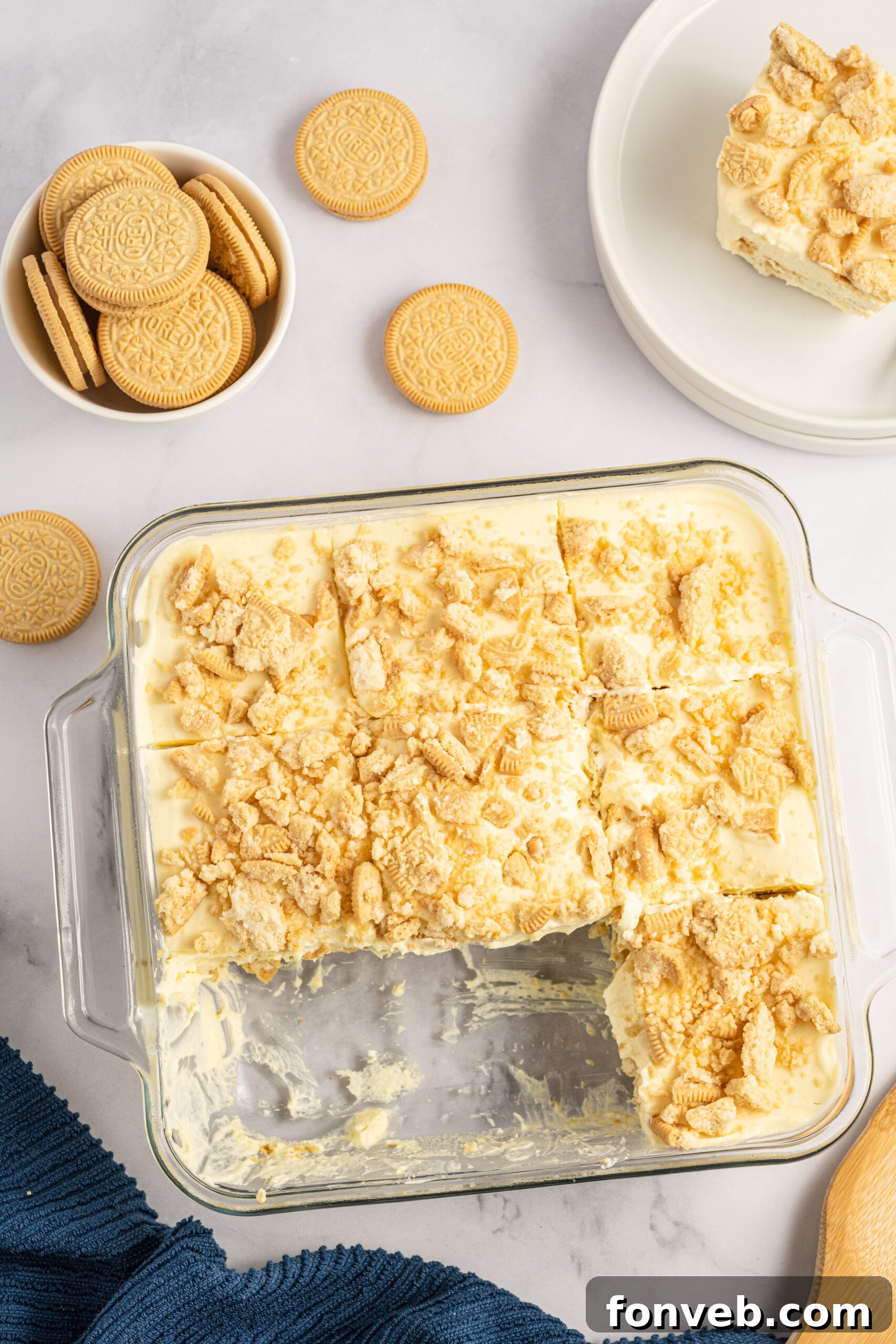 Golden Oreo No-Bake Delight 5 Overhead view of Golden Oreo Icebox Cake in a clear baking dish with two slices removed.