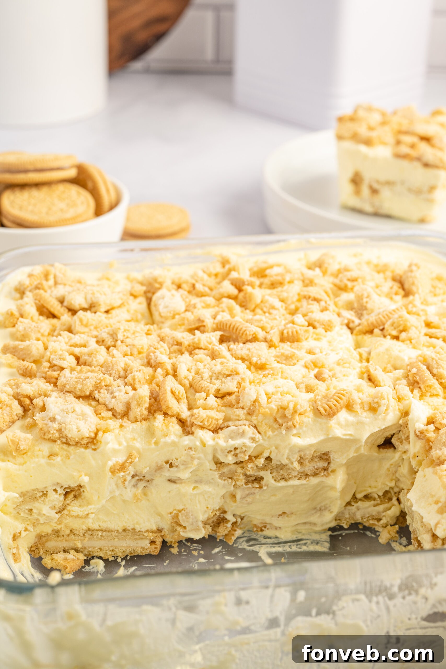 Golden Oreo No-Bake Delight 6 Close up view of Golden Oreo Icebox Cake in a clear baking dish with two slices removed.