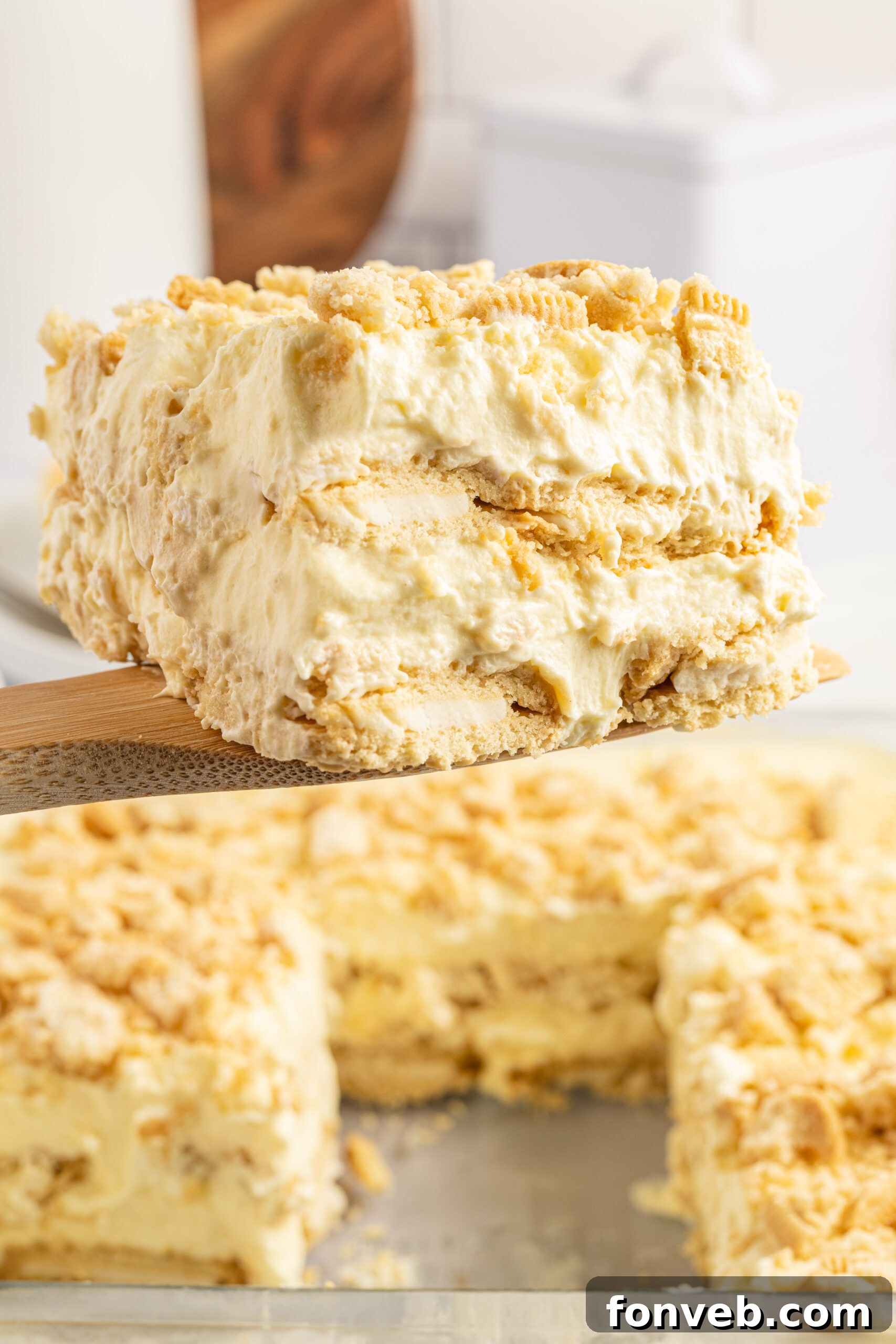 Golden Oreo No-Bake Delight 7 Front view of a slice of Golden Oreo Icebox Cake on a wooden spatula.