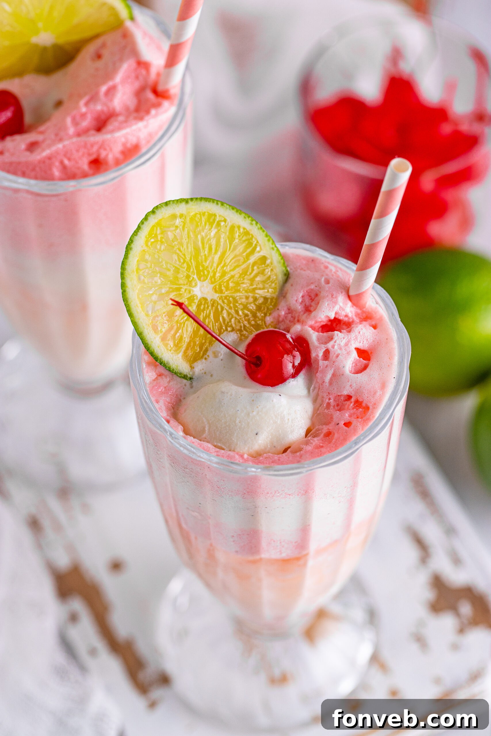 Overhead view of Dirty Shirley Float in a clear glass topped with a lime slice and cherry.