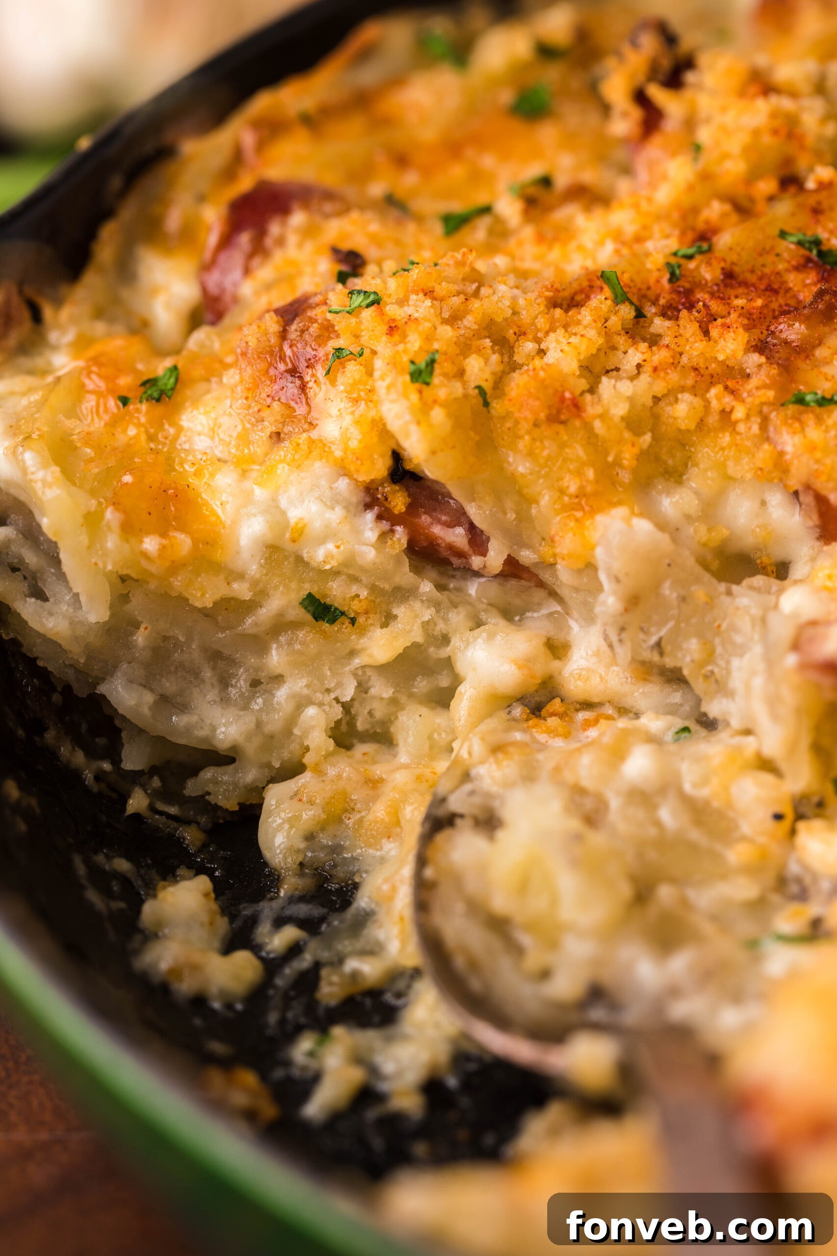 Creamy Sausage and Potato Gratin 19 Close up view of Au Gratin Potatoes & Ham in a cast iron skillet with a serving removed.