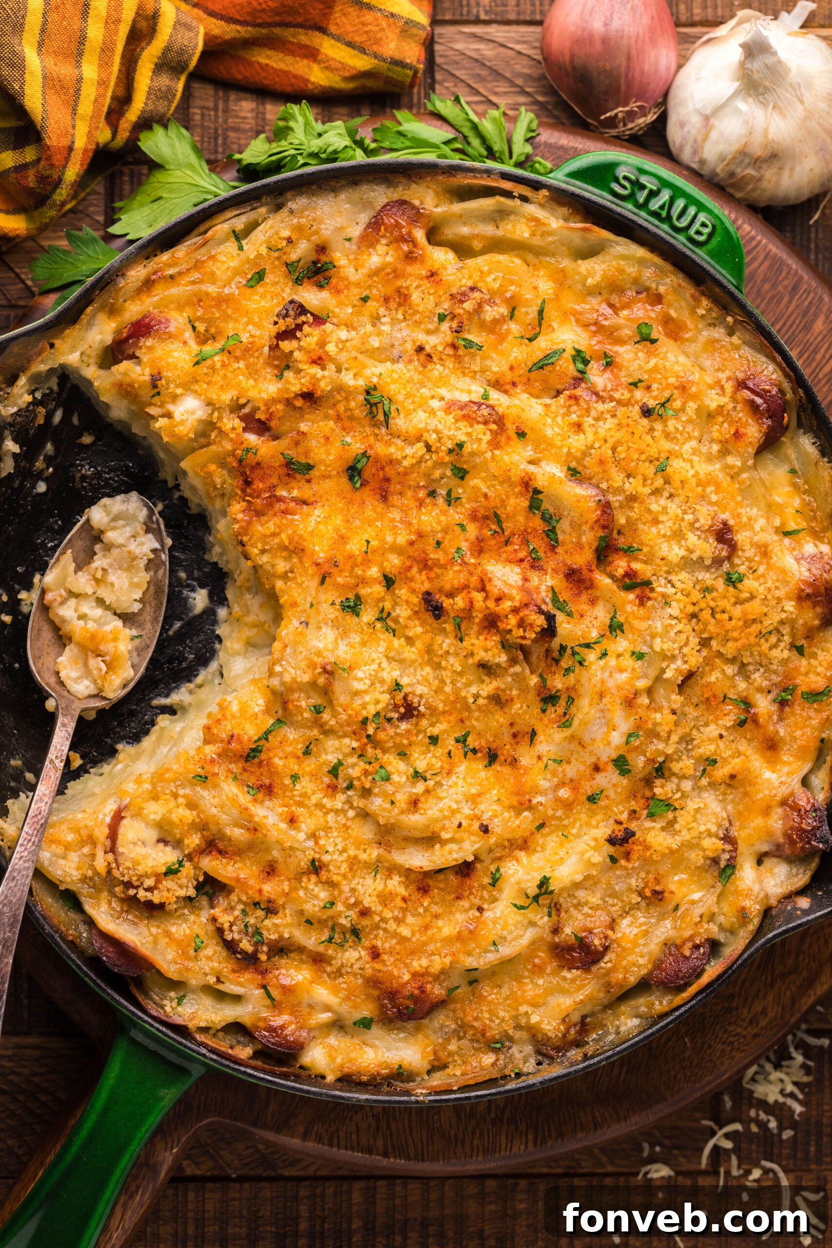 Creamy Sausage and Potato Gratin 24 Overhead view of Au Gratin Potatoes & Ham in a cast iron skillet with a serving removed.