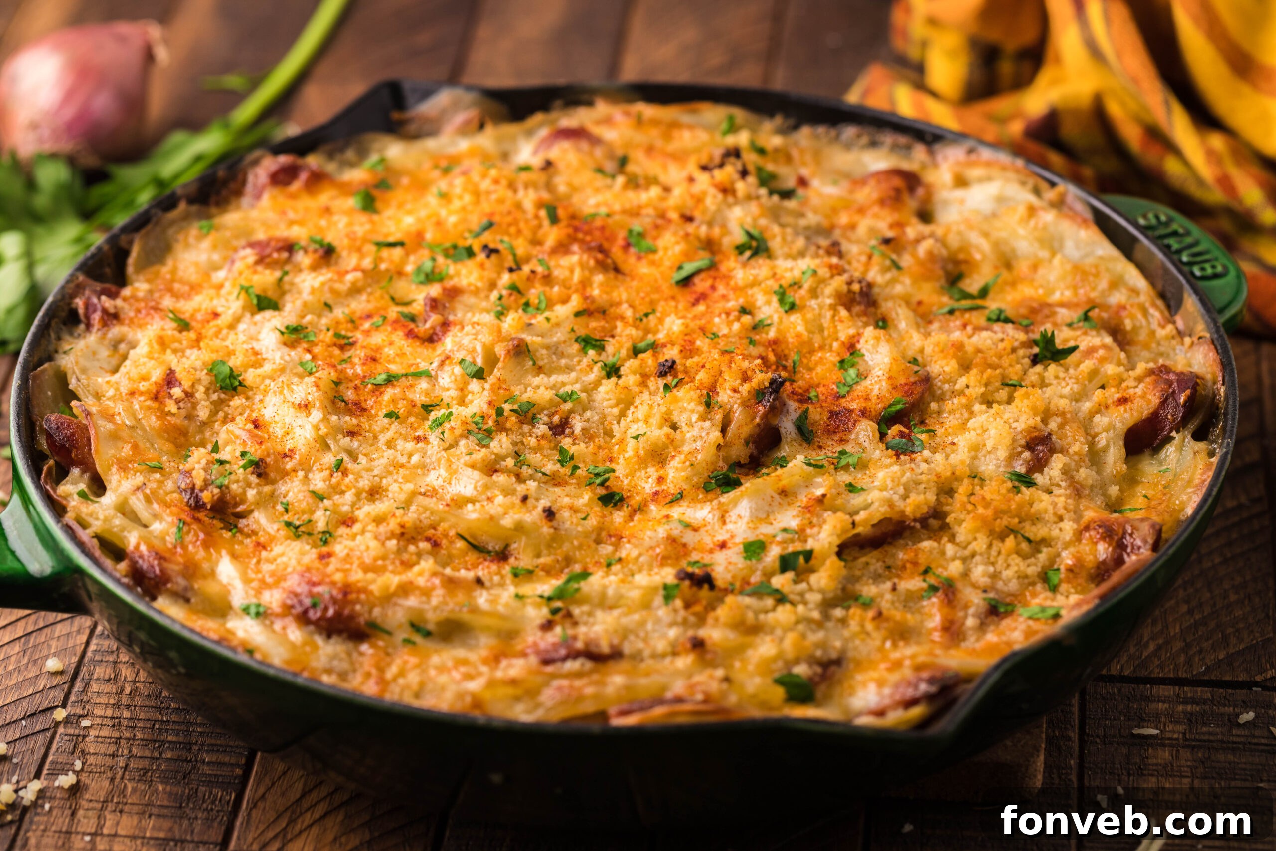 Creamy Sausage and Potato Gratin 8 side view Au Gratin Potatoes & Sausage in a cast iron skillet on a wooden table