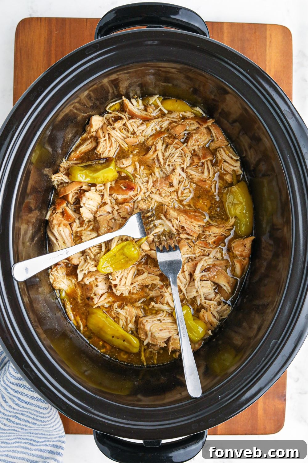 chicken being shredded with two forks 