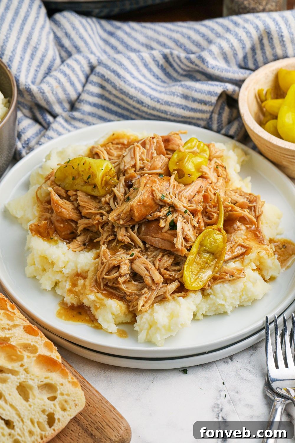 mississippi chicken on plate with bread on the side of table