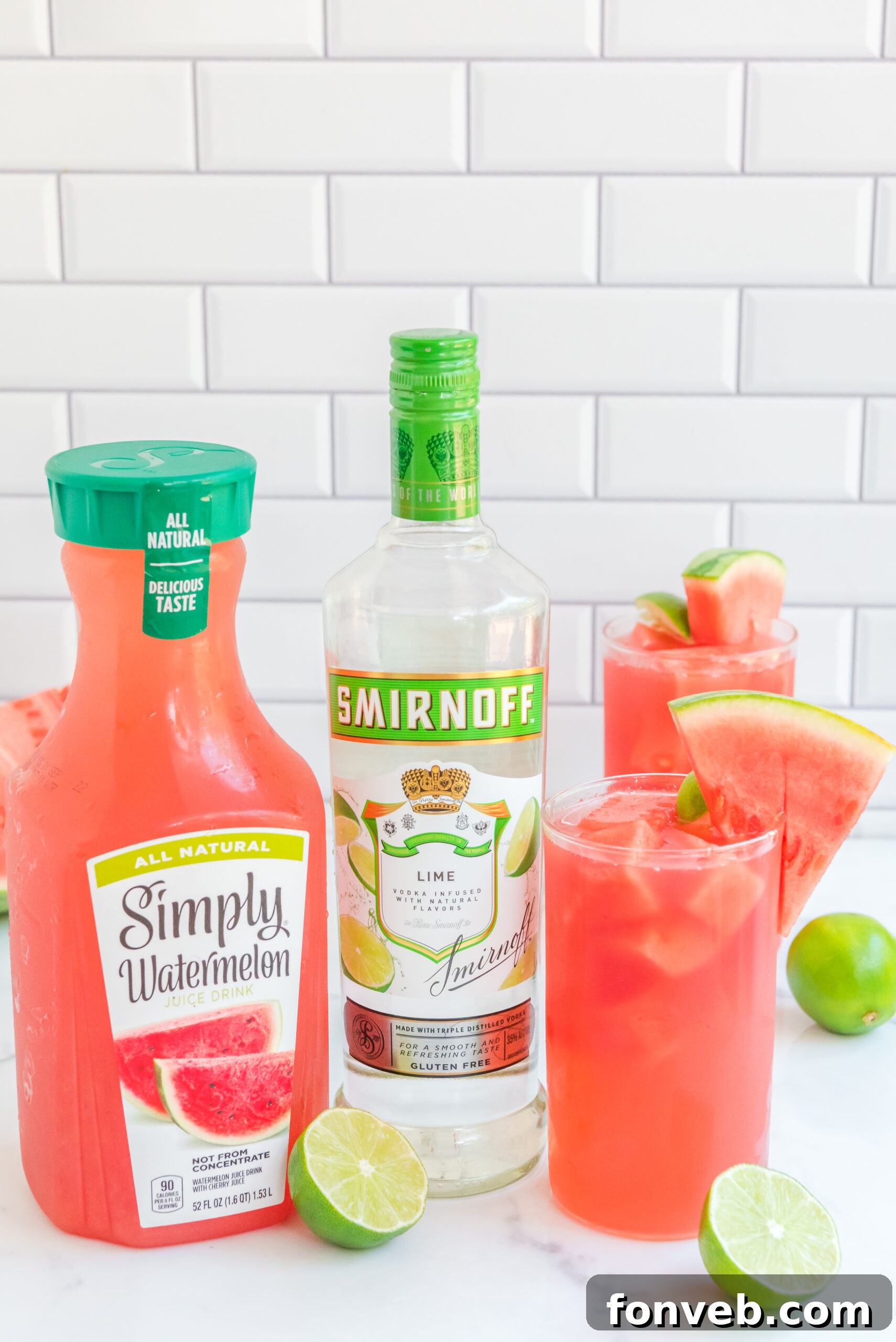 front view of Watermelon Cocktail in two clear glasses garnished with lime and watermelon slices.