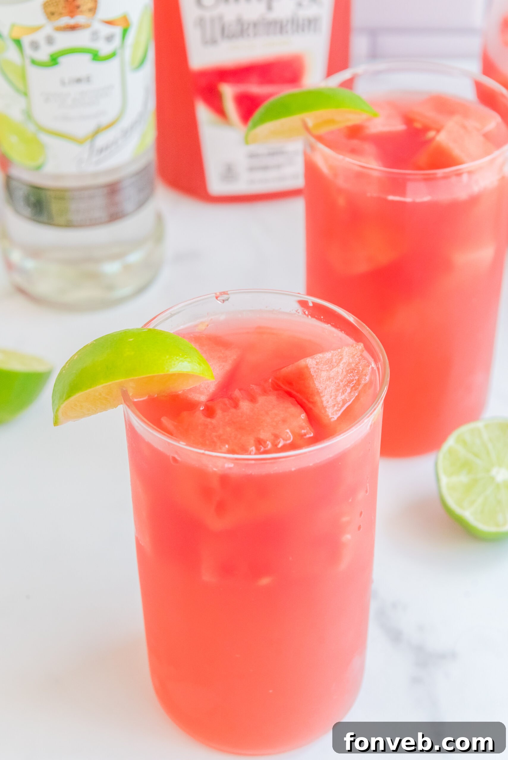 Close up view of Watermelon Cocktail in a clear glass garnished with a lime wedge.