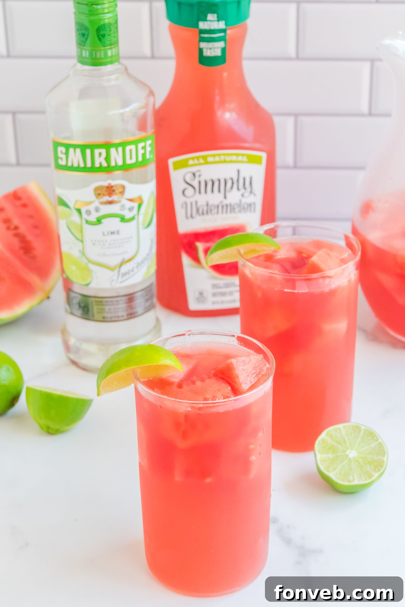 Front view of Watermelon Cocktail in two clear glasses garnished with a lime wedge.