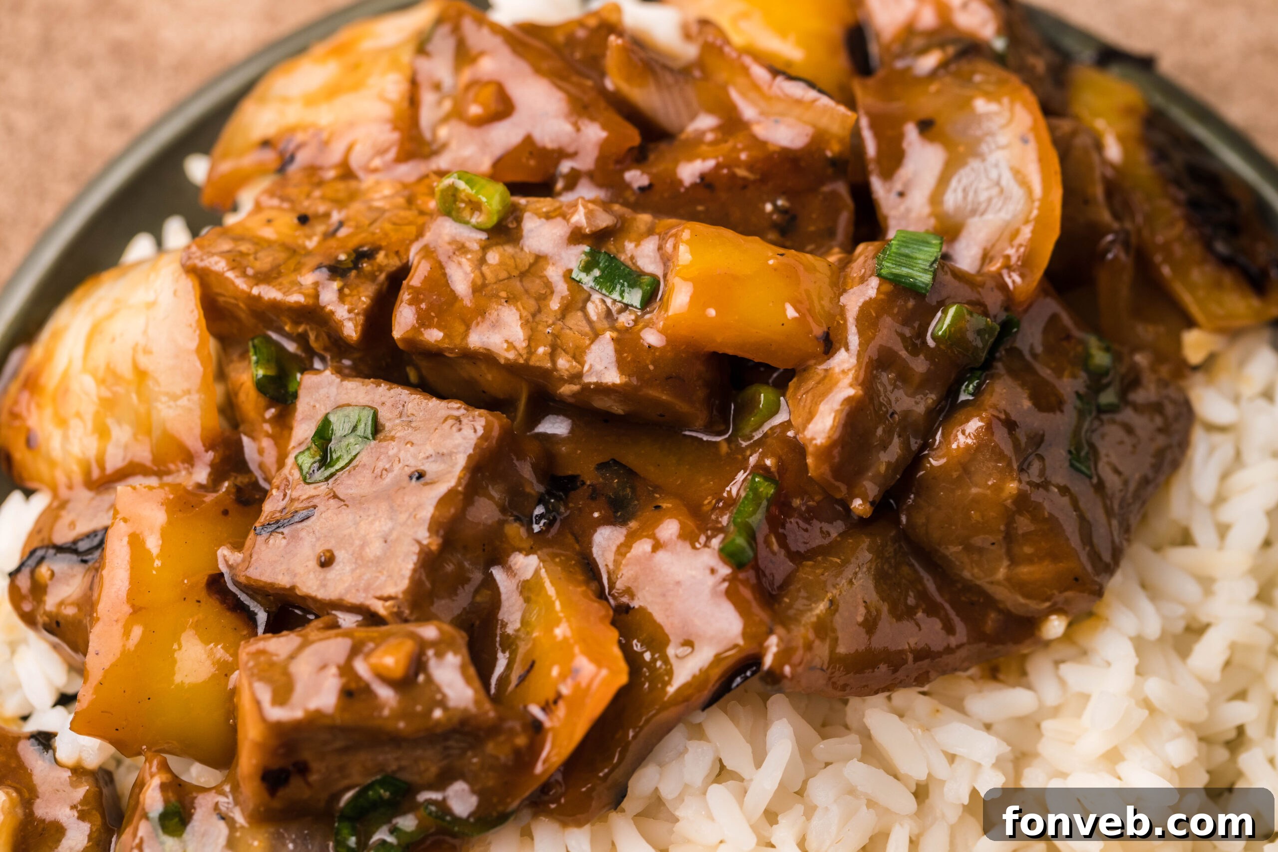 Close up view of Teriyaki Steak Bites in a black dish with a side of white rice.