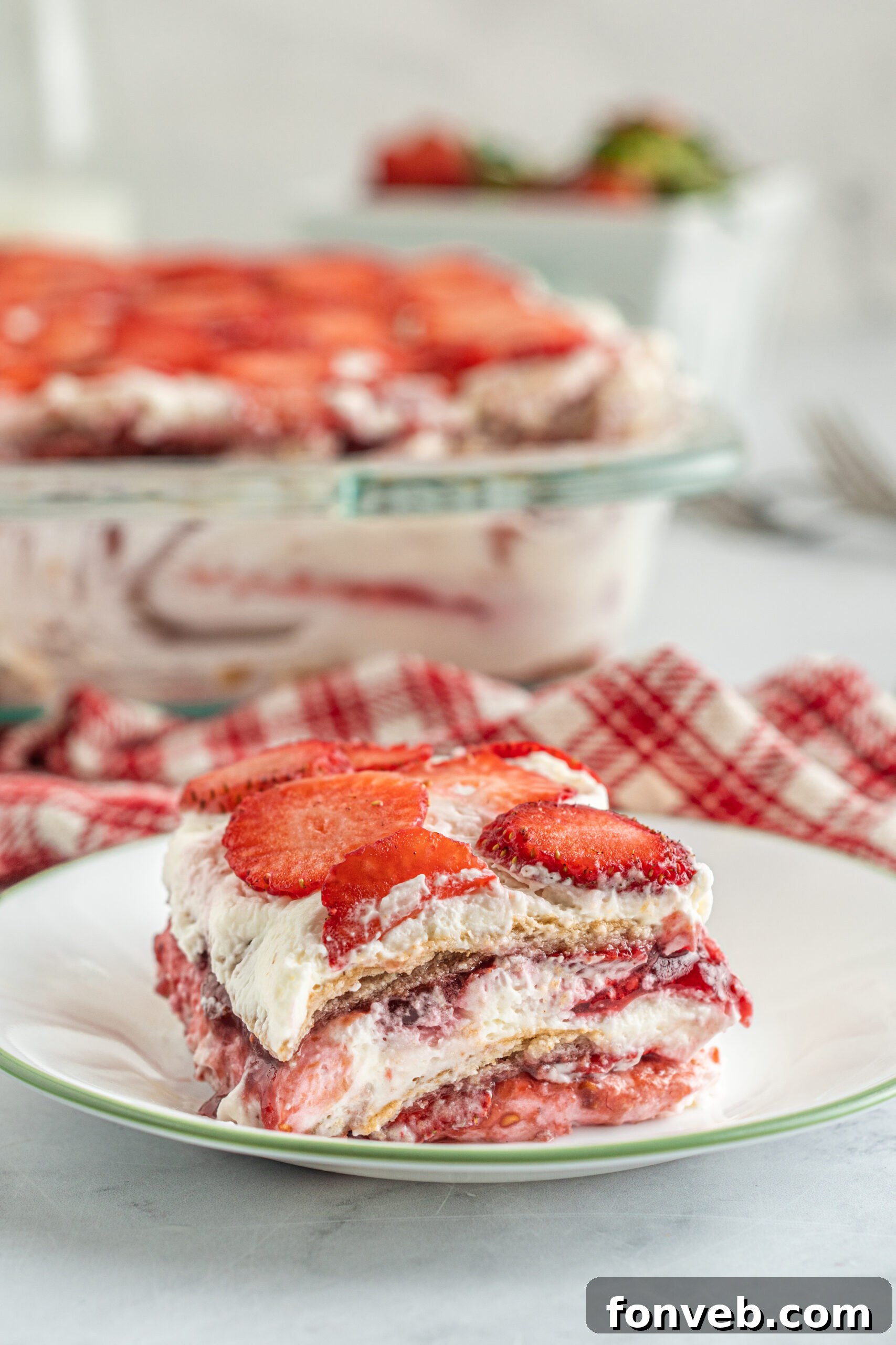A piece of Strawberry Icebox Cake on a white and green plate. 