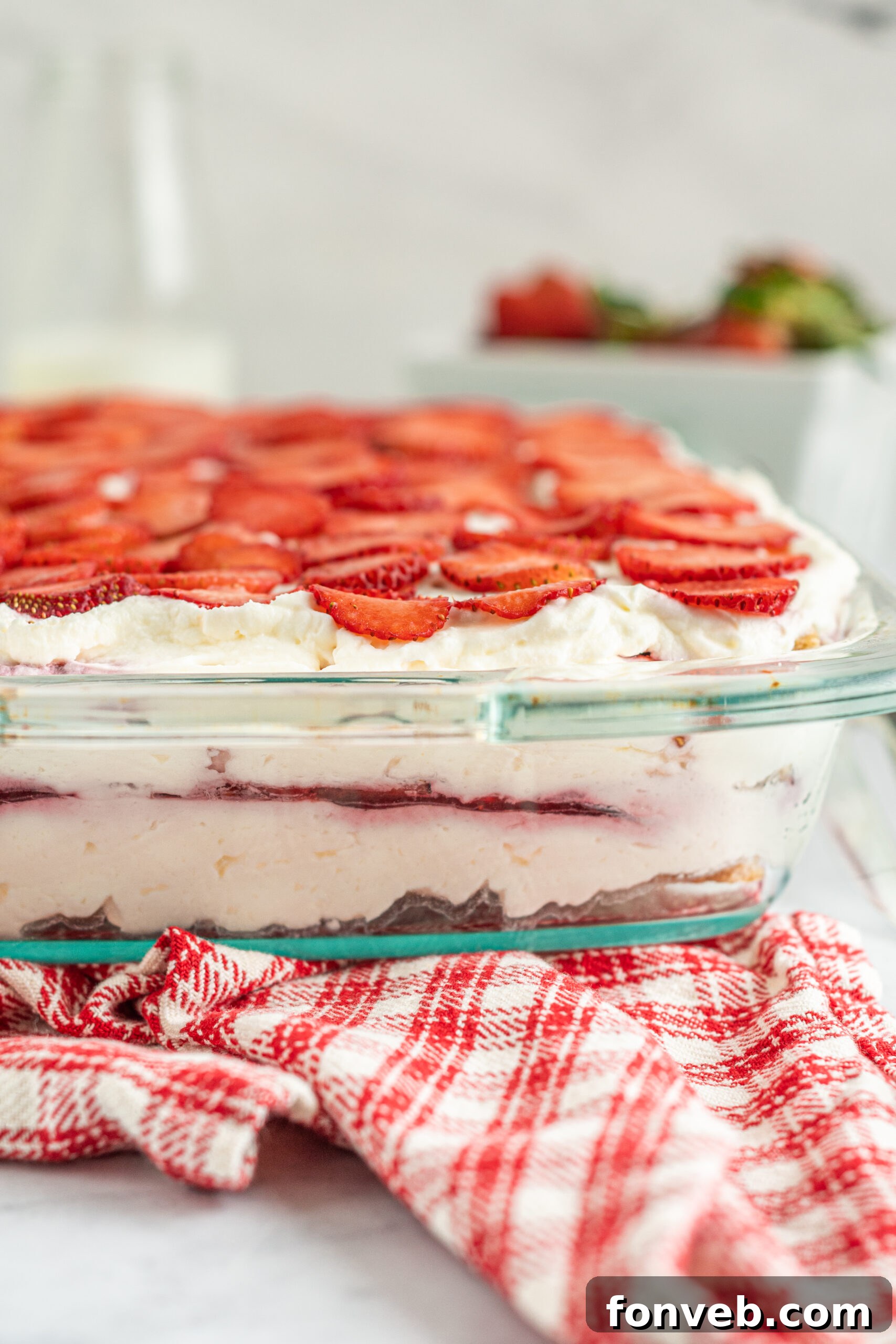 Close up side view of Strawberry Icebox Cake in a clear baking dish. 