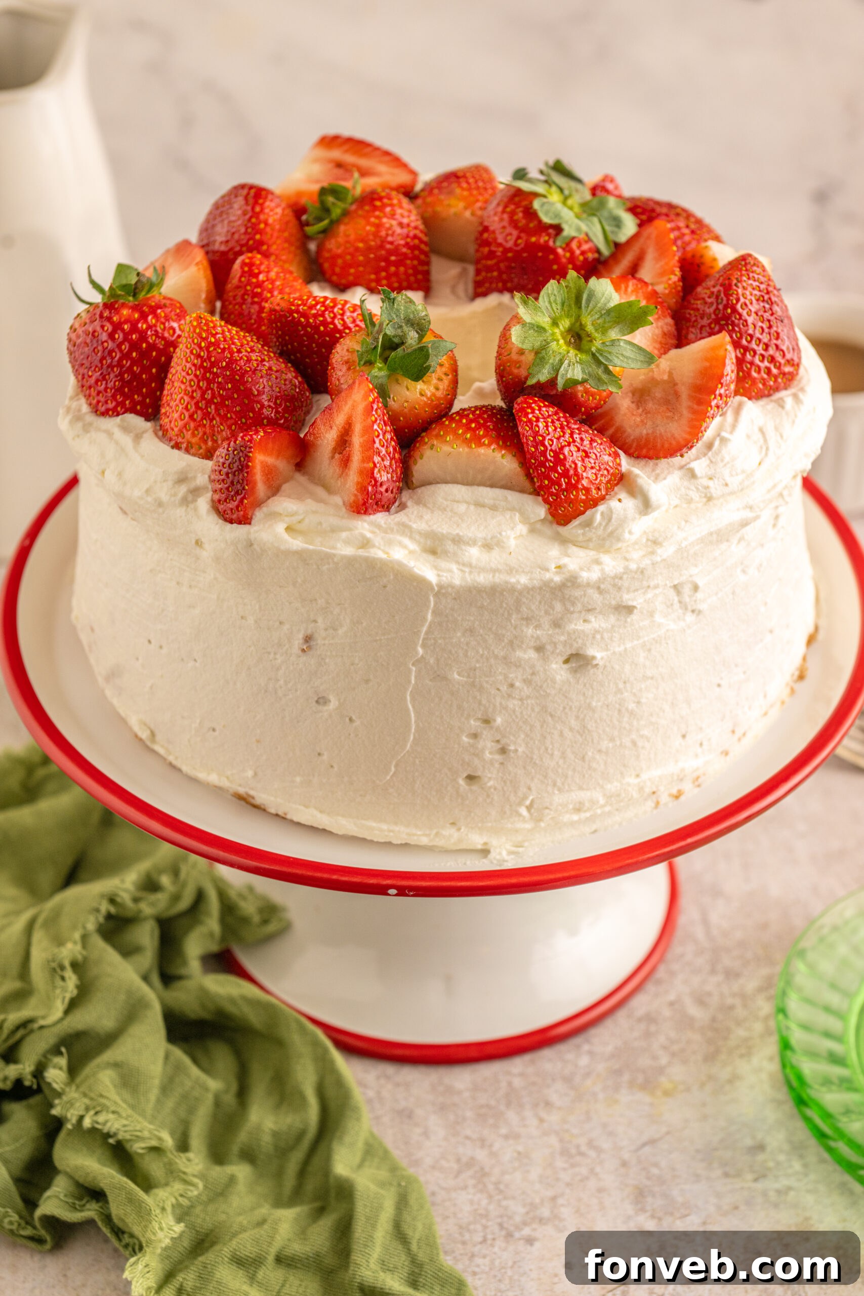 Side view of the Strawberry Angel Food Cake topped with fresh strawberries. 
