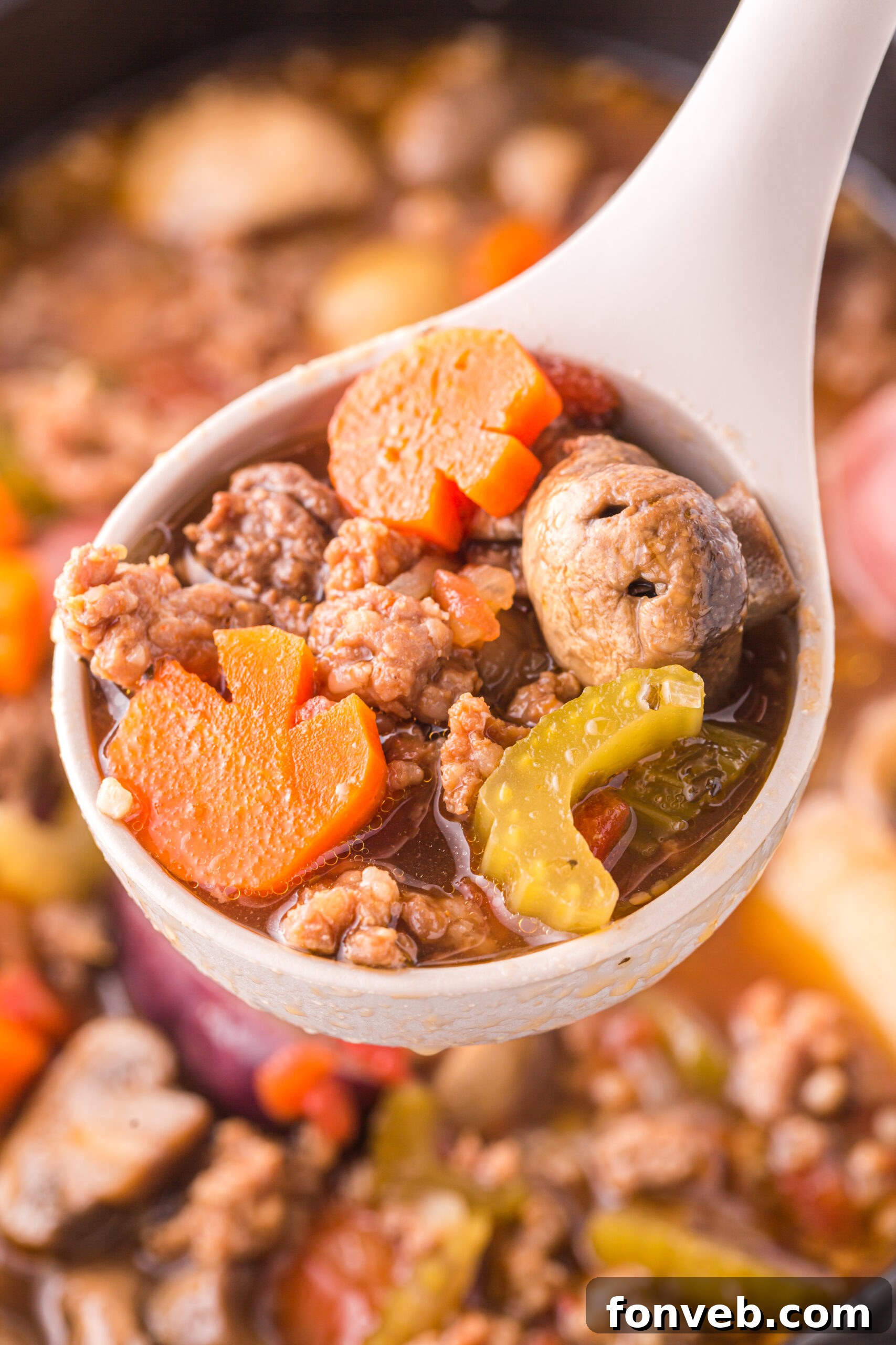 Close up view of a serving spoon scooping Witches Brew Stew from the slow cooker.