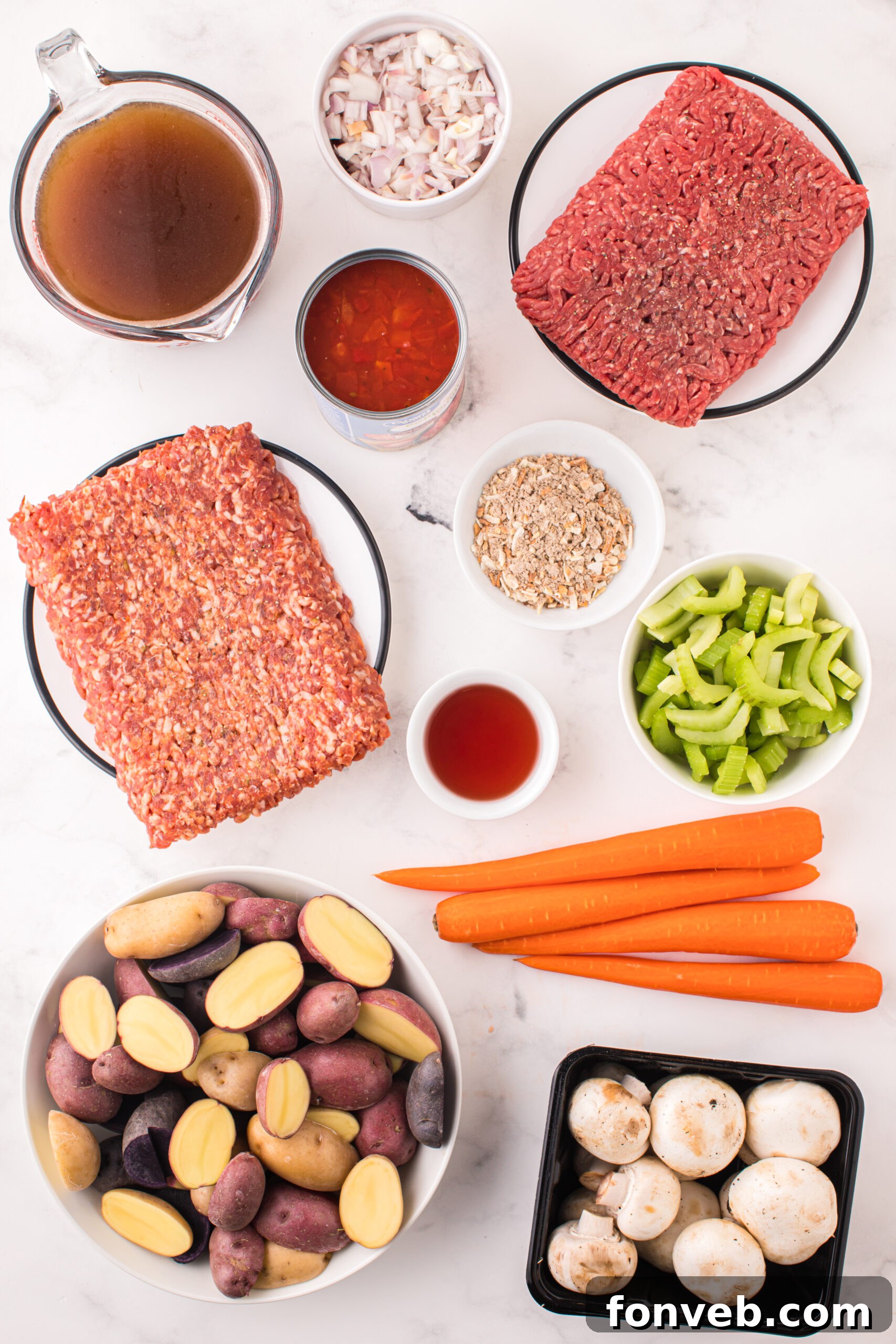 Overhead view of all the fresh ingredients laid out before cooking, including meats, vegetables, and broth.