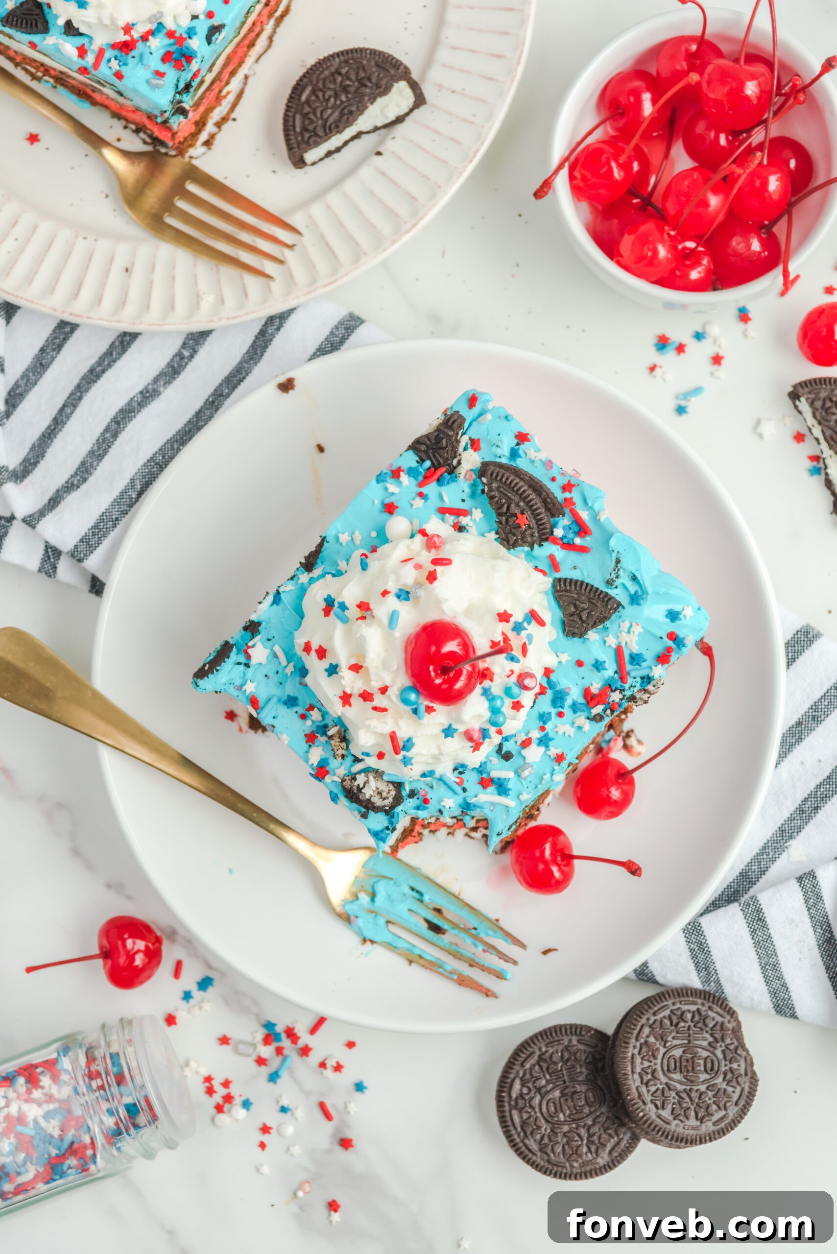 Overhead view of a slice of Patriotic Ice Cream Sandwich Cake with a bite removed by a silver fork.