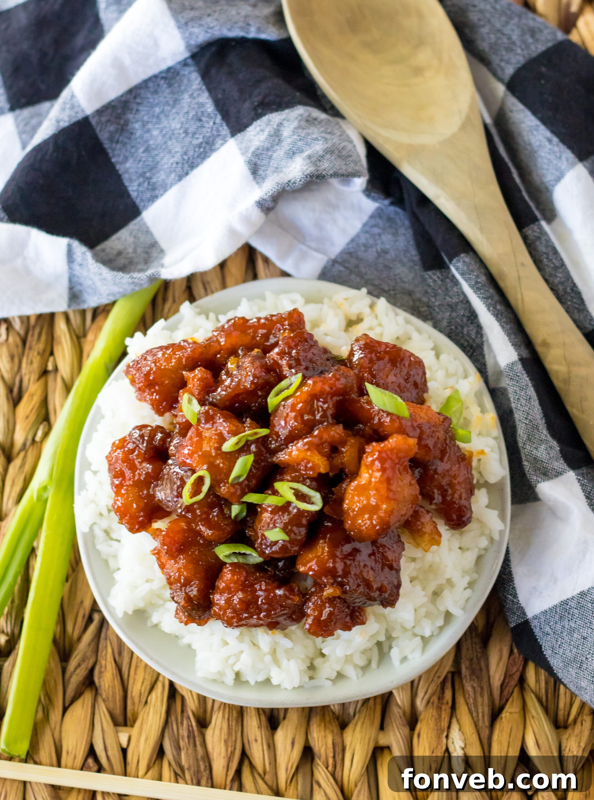 Overhead view of Slow Cooker Firecracker Chicken over white rice in a white bowl, elegantly presented.