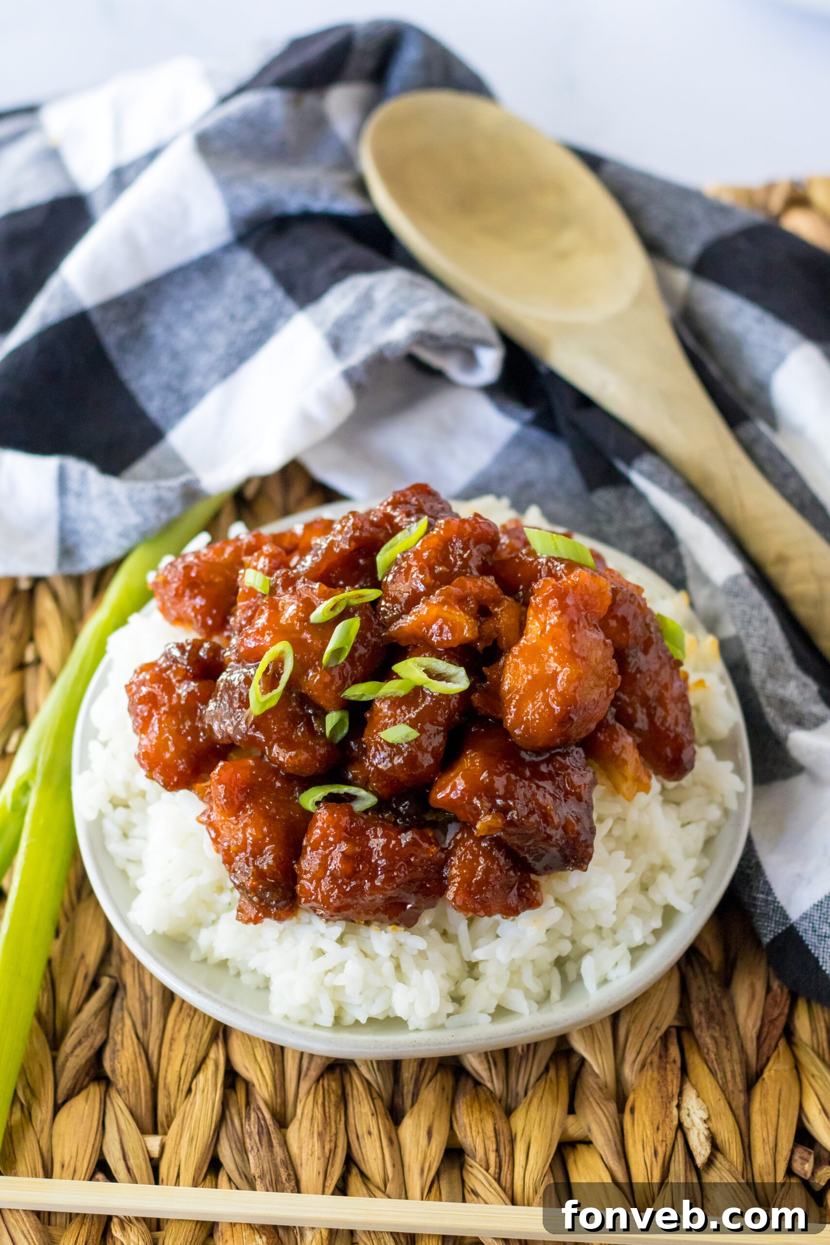 Overhead view of Slow Cooker Firecracker Chicken over white rice in a white bowl, ready for plating.
