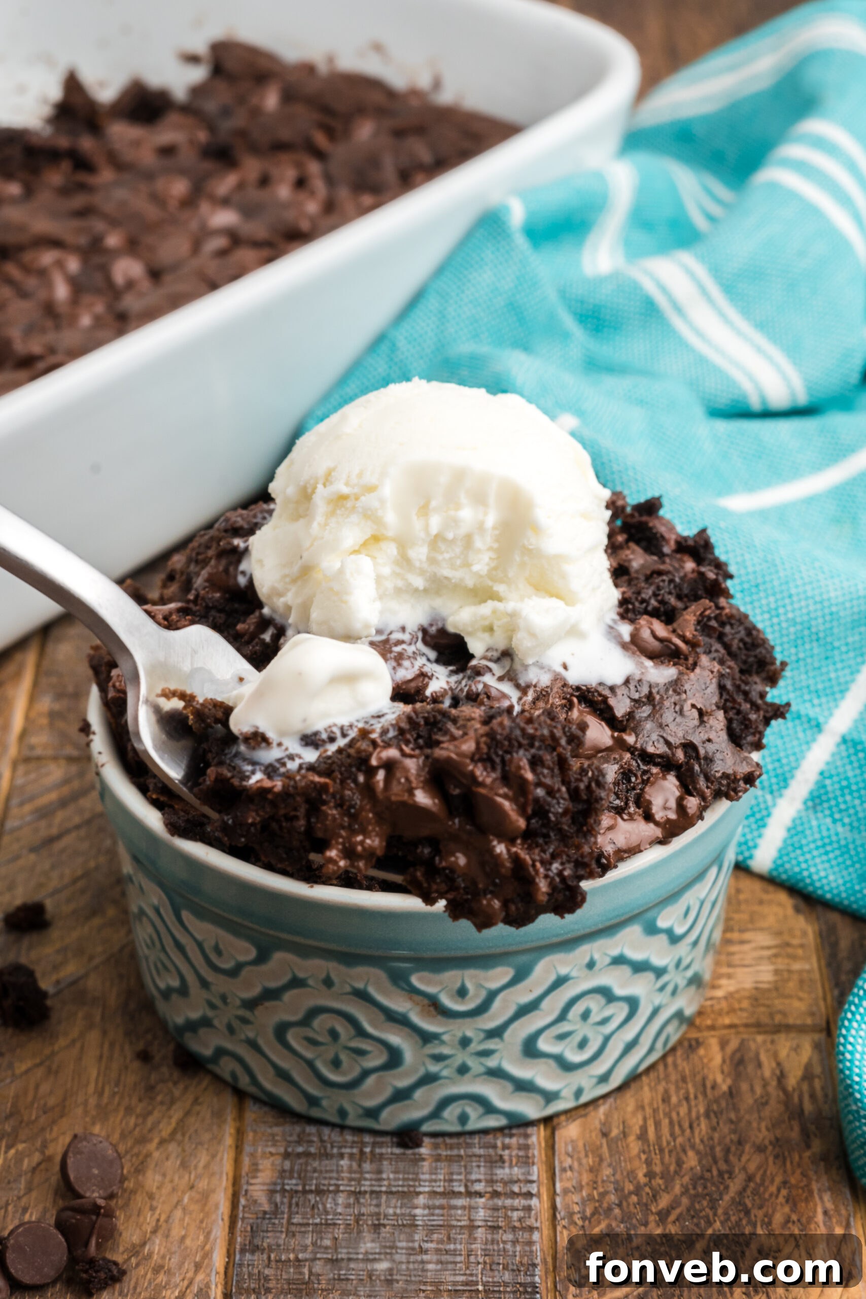 A silver fork captures a perfect bite of chocolate dump cake, showcasing the cake's moist interior and ready-to-eat appeal.