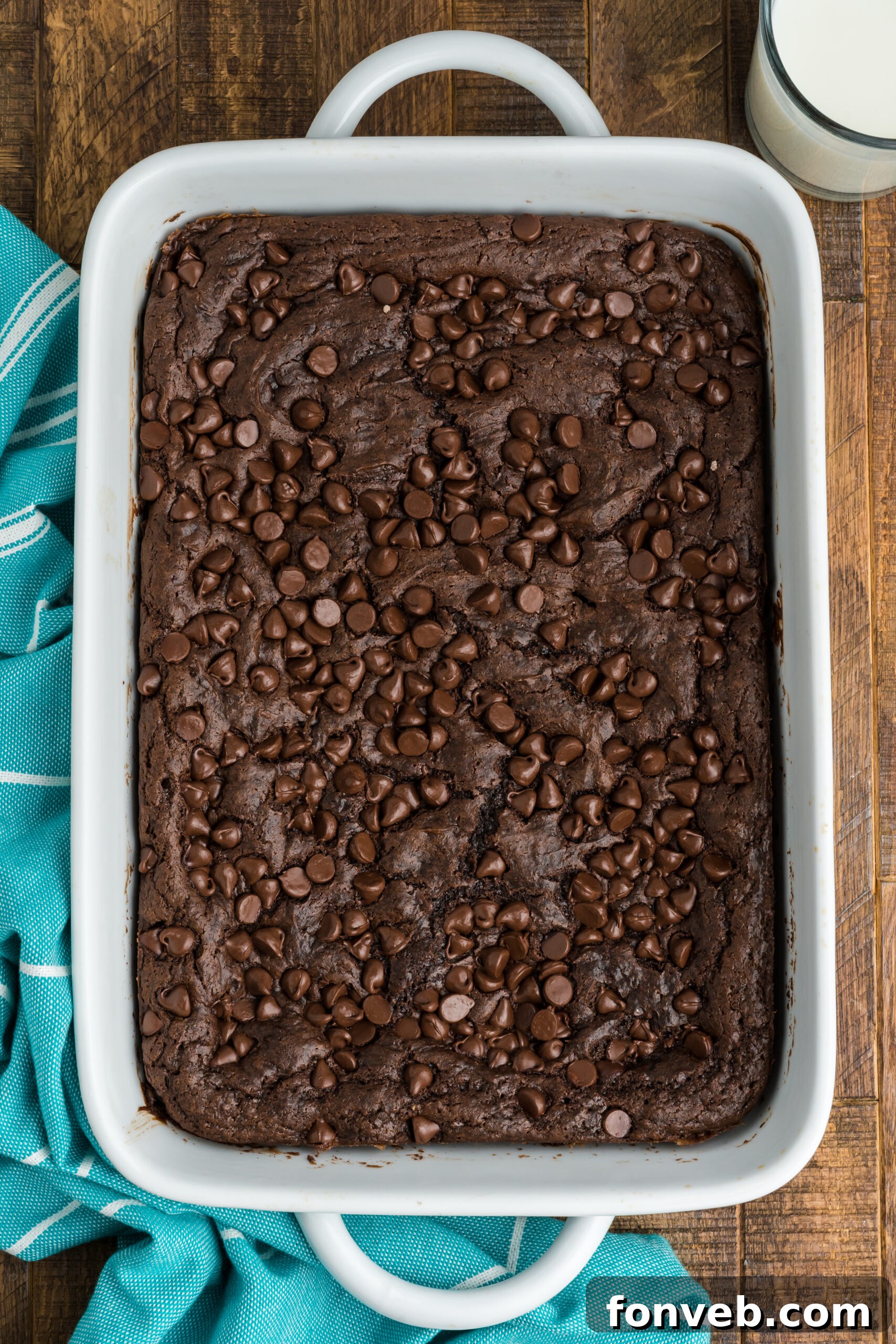An overhead shot showcasing the entire chocolate dump cake baked to perfection in a white rectangular baking dish, with its inviting, crinkled top layer.