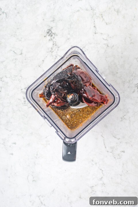 Step-by-step image of blending the Birria sauce ingredients.