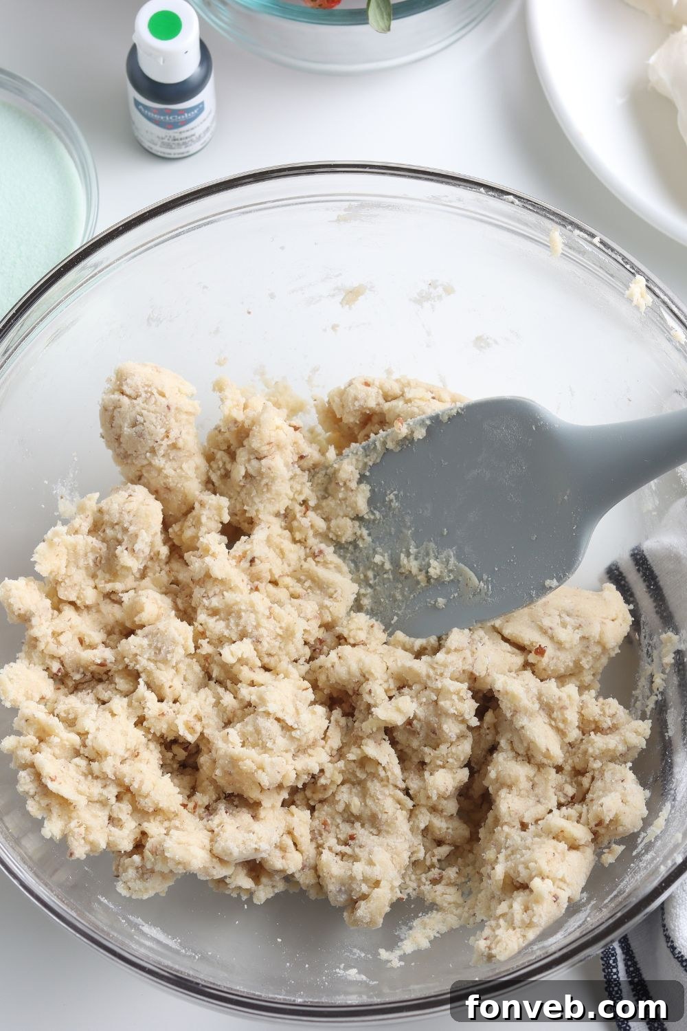 Crust mixture in a bowl on a wooden table, ready to be pressed.