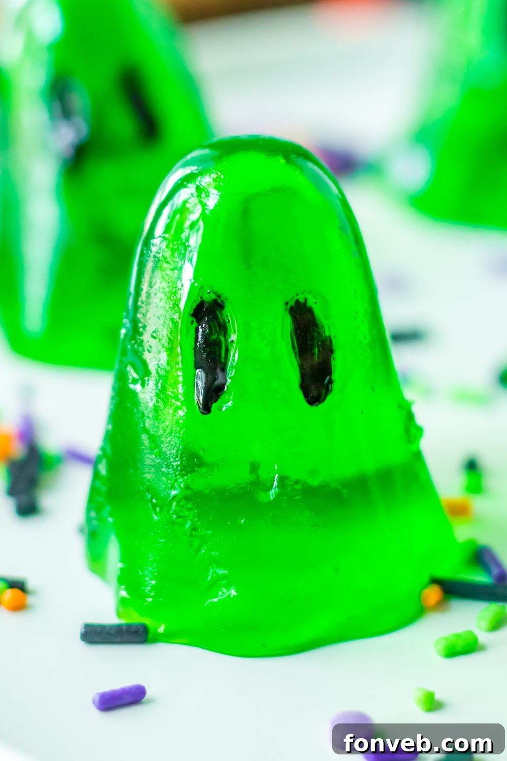 Spooky Spirit Shooters 3 A close-up shot of ghost-shaped jello shots resting on a table, adorned with colorful Halloween sprinkles.