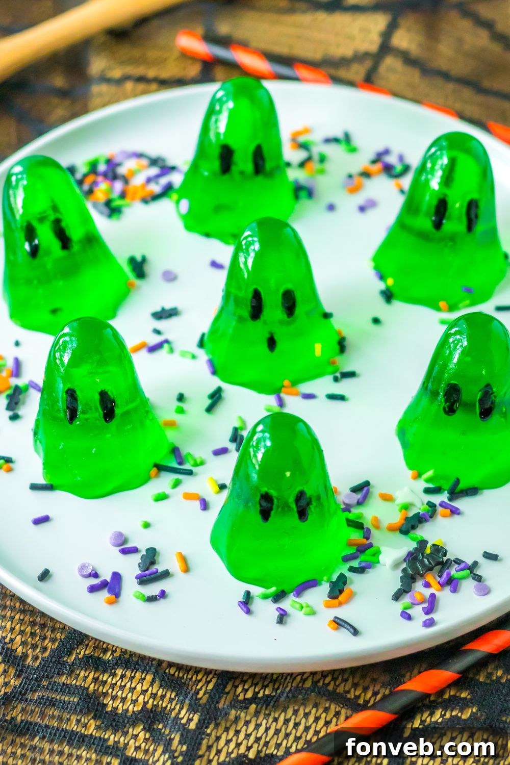 Spooky Spirit Shooters 7 A plate featuring several perfectly formed ghost-shaped jello shots, surrounded by colorful Halloween sprinkles, ready to serve.